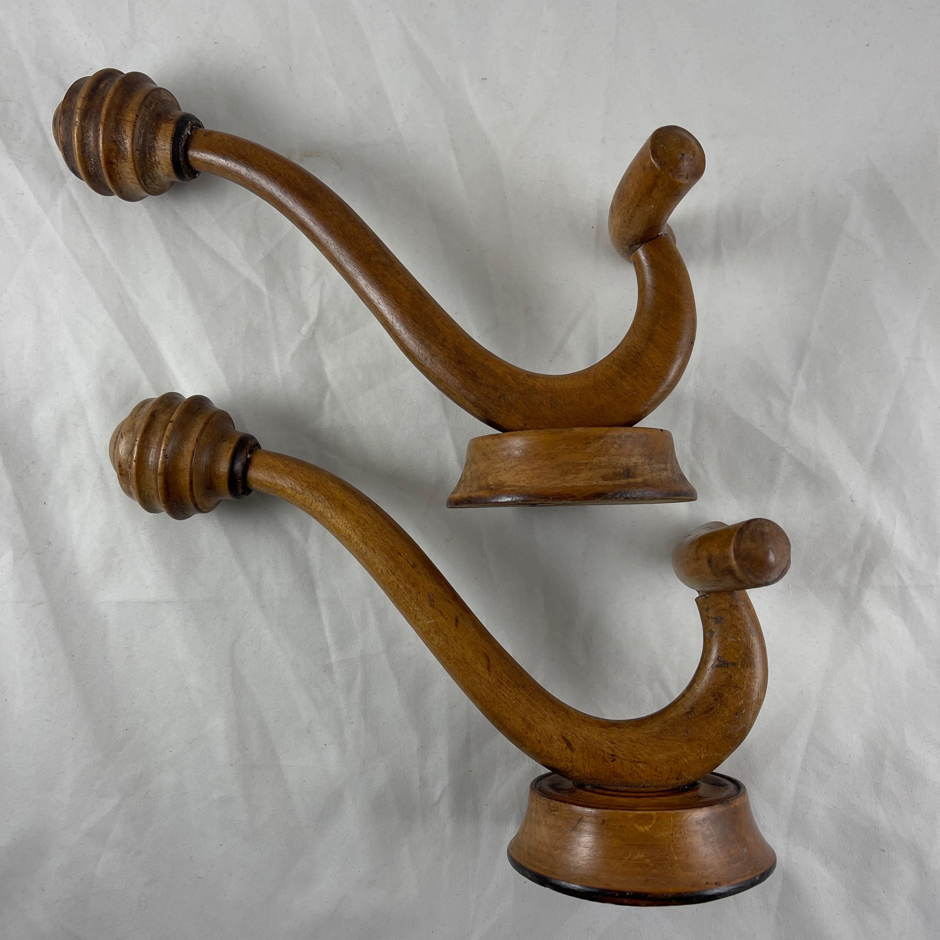 A pair of French Art Nouveau period bentwood hat and coat pegs, circa 1910 – 1920.

The wall mounted Beechwood hooks have turned upper pegs for holding a hat, with a u-shaped peg for a coat, mounted on a beveled round wooden disc.

Most often