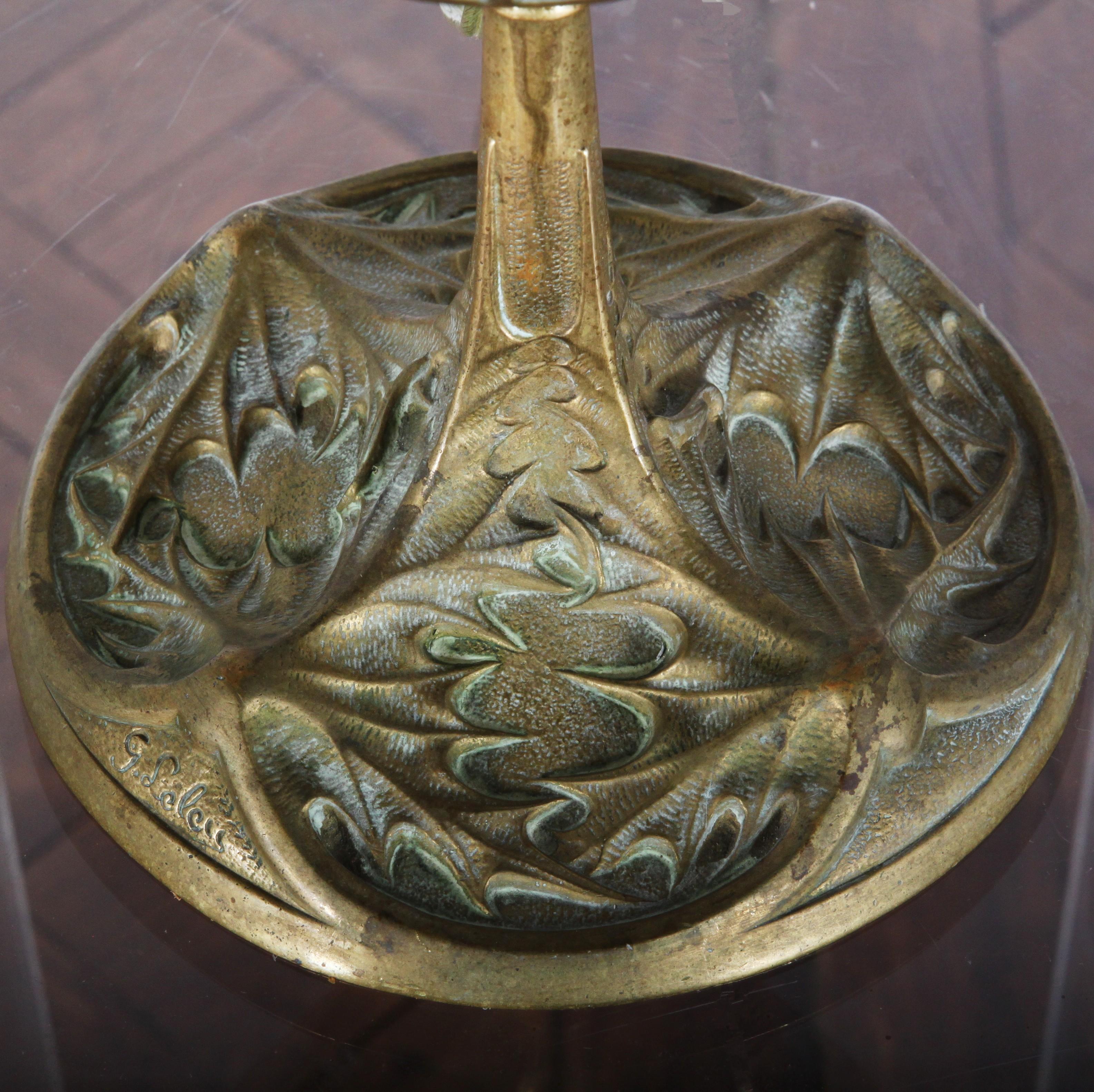 A French Art Nouveau period brass oil lamp newly-rewired to modern standards. Textured brass dome with inset opalescent glass cabochons above a tautly-sculpted organic Art Nouveau base. Signed J. Leleu. 

Jules Leleu (June 17, 1883–1961) was a