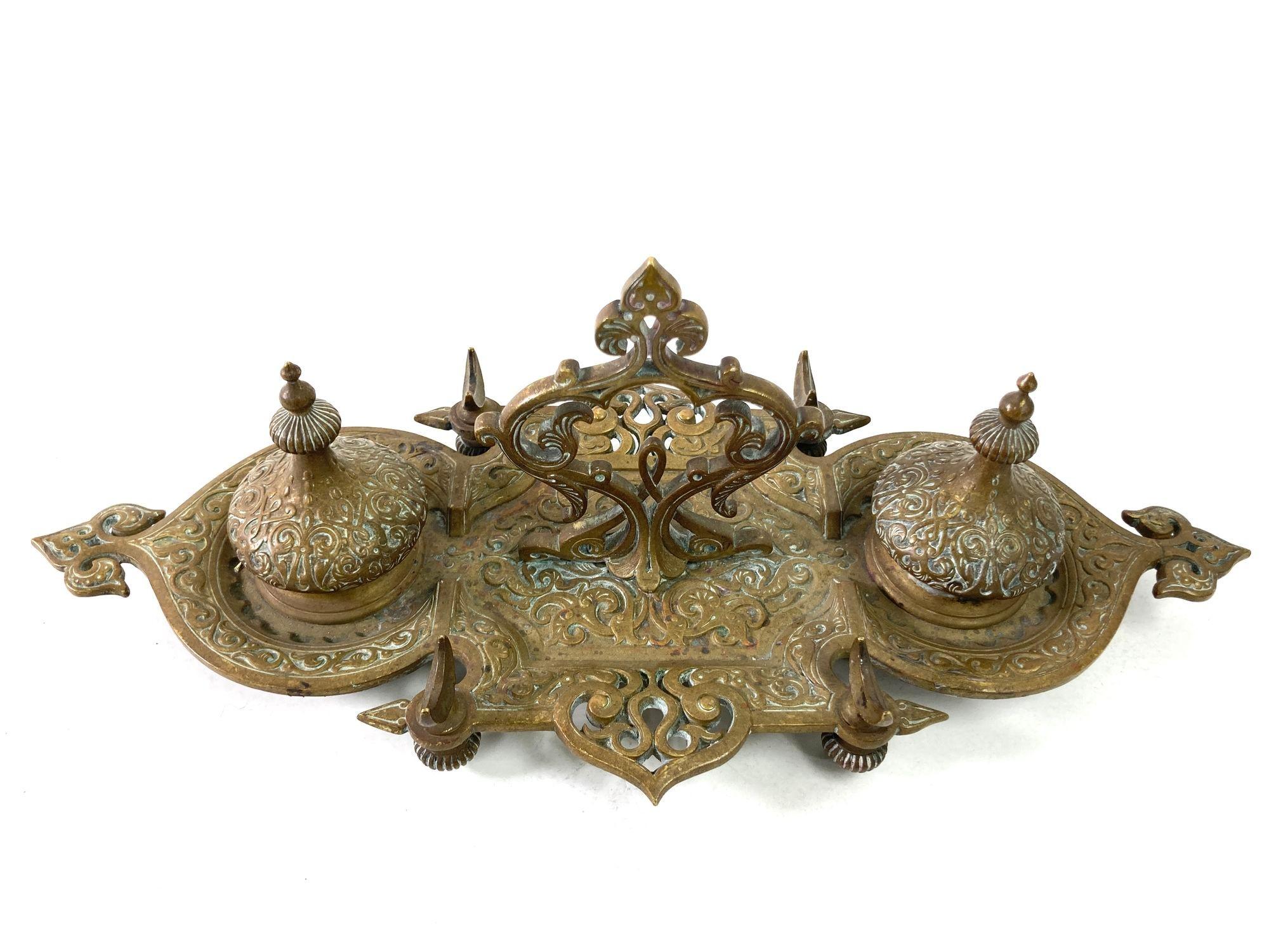 French Art Nouveau brass footed double ink well Filigree bronze Moorish Style.
Vintage Art Nouveau Victorian metal cast bronze ornate filigree double well inkwell and holders, very ornate with Orientalist influence with domes, crescent moon and