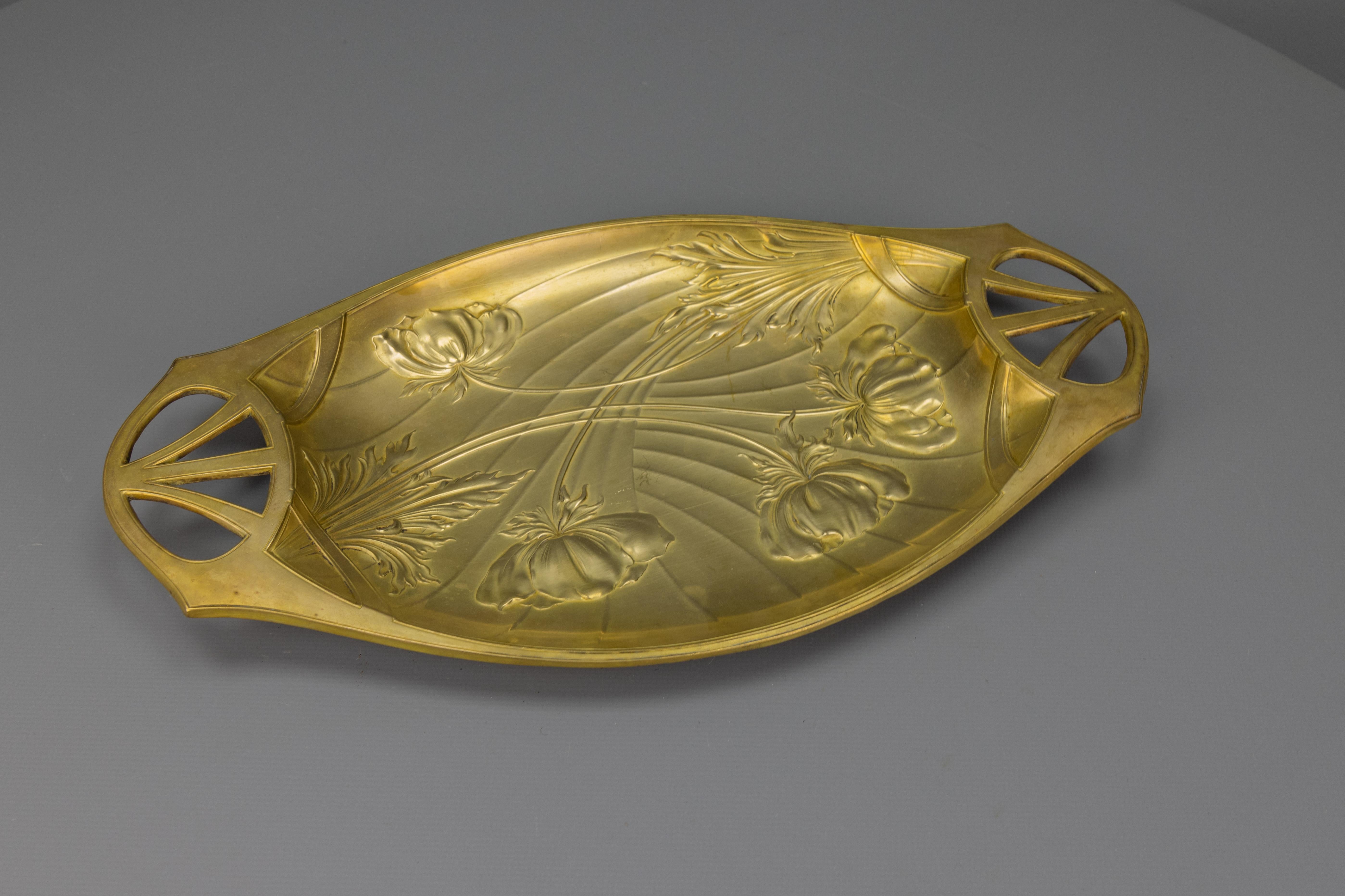 Un vassoio in ottone in stile Art Nouveau francese, riccamente decorato con motivi floreali: un raffinato esempio di artigianato dell'inizio del XX secolo.
Questo elegante vassoio in ottone Art Nouveau francese, risalente al 1920 circa, presenta una