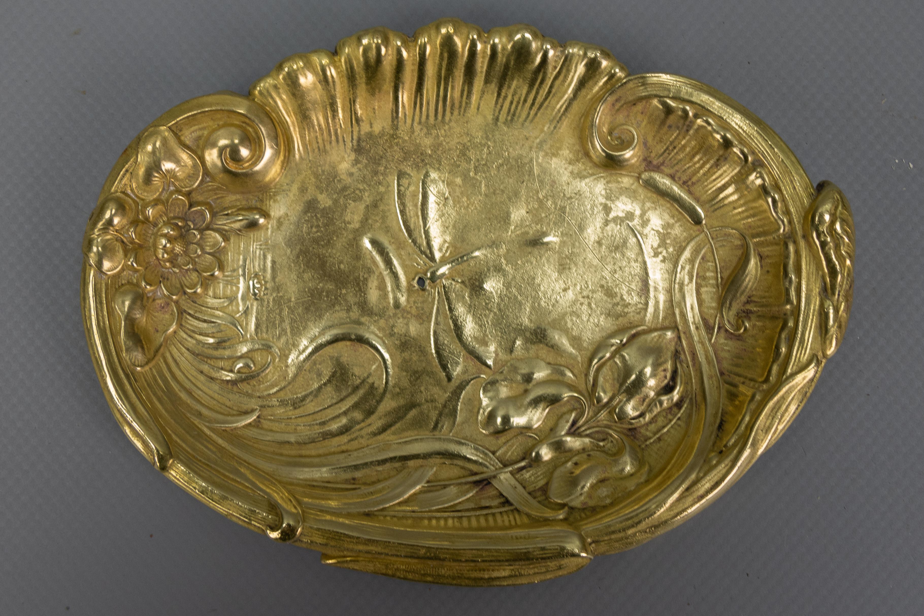 French Art Nouveau brass card or pin tray, vide-poche, 1920s. 
This delightful card tray or pin tray, vide-poche, is made of brass and showcases a relief design of a dragonfly, adorned with an iris flower and aquatic plants, which is typical of the