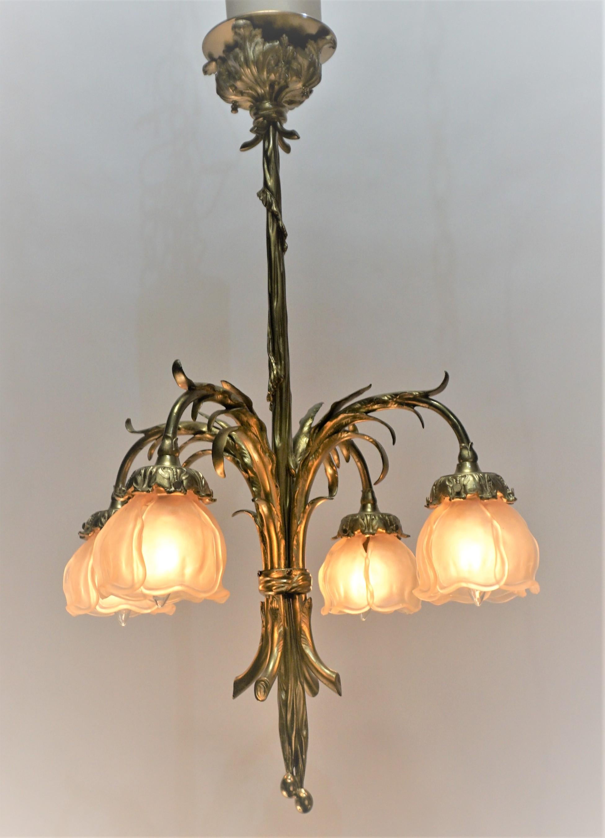 Early 20th century bronze and glass art nouveau chandelier. Beautiful design bronze with very light color pink shades and each shade is consist of four parts that have been together metal spring to make one shade.
Measurement: width, the widest