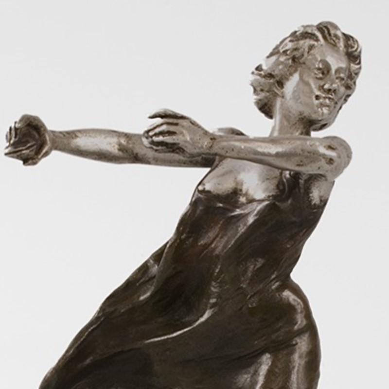 A French Art Nouveau bronze sculpture of a Castanet dancer in motion with flowing gown by Rupert Carabin. A French Art Nouveau bronze sculpture of a castanet dancer in motion with flowing gown by Rupert Carabin. This barefoot woman holds her