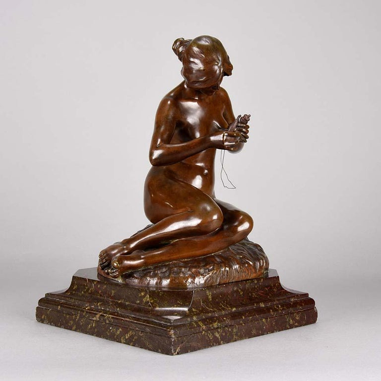 A delightful Art Nouveau early 20th century bronze figure of a naked woman sat upon a rock spinning wool, exhibiting excellent rich brown patina and fine hand finished detail. Raised on a shaped marble base and signed A Clerget.