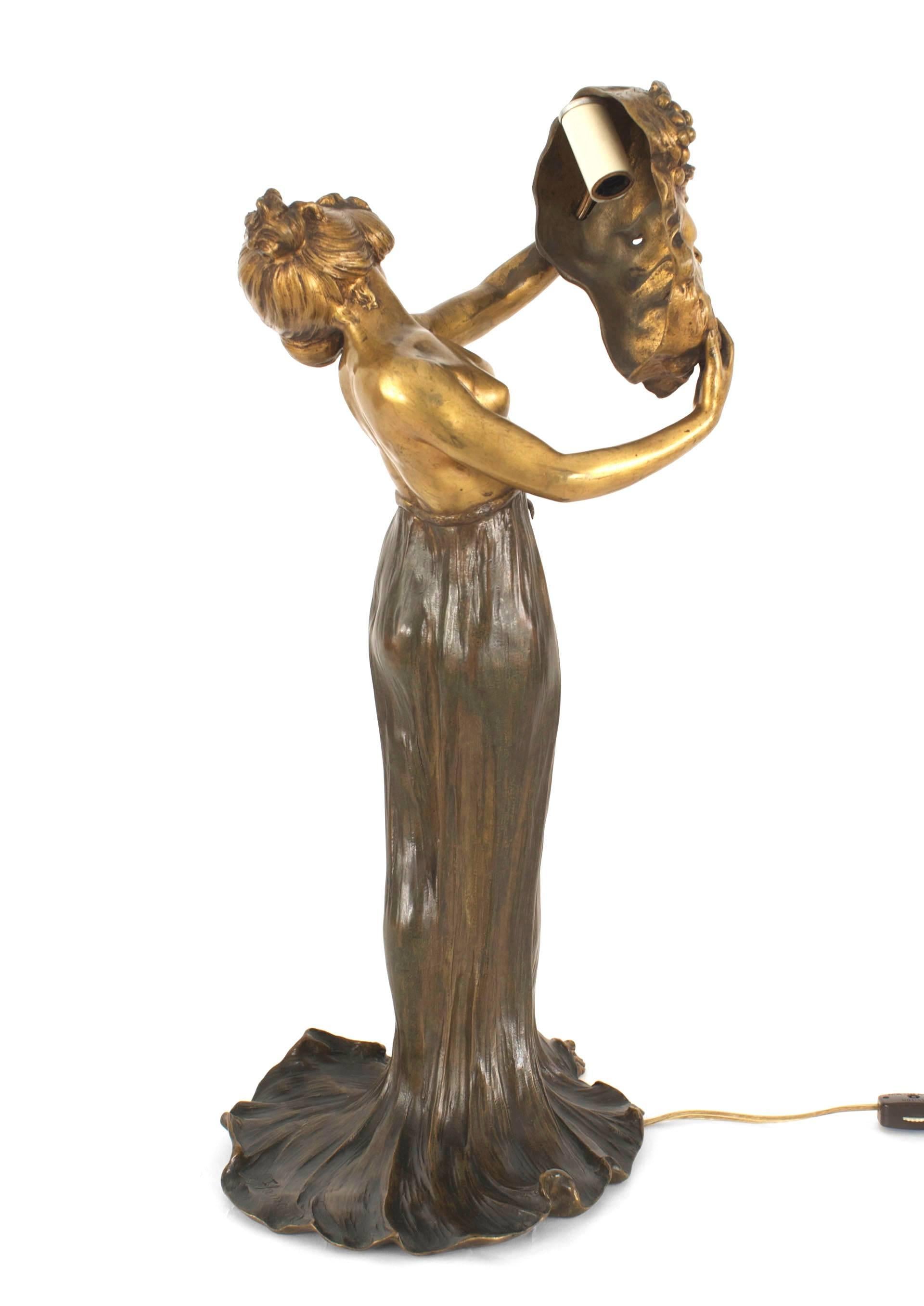 Lampe de table en bronze Art Nouveau représentant une femme tenant un masque d'homme grec (signée : FLAMAND).
 