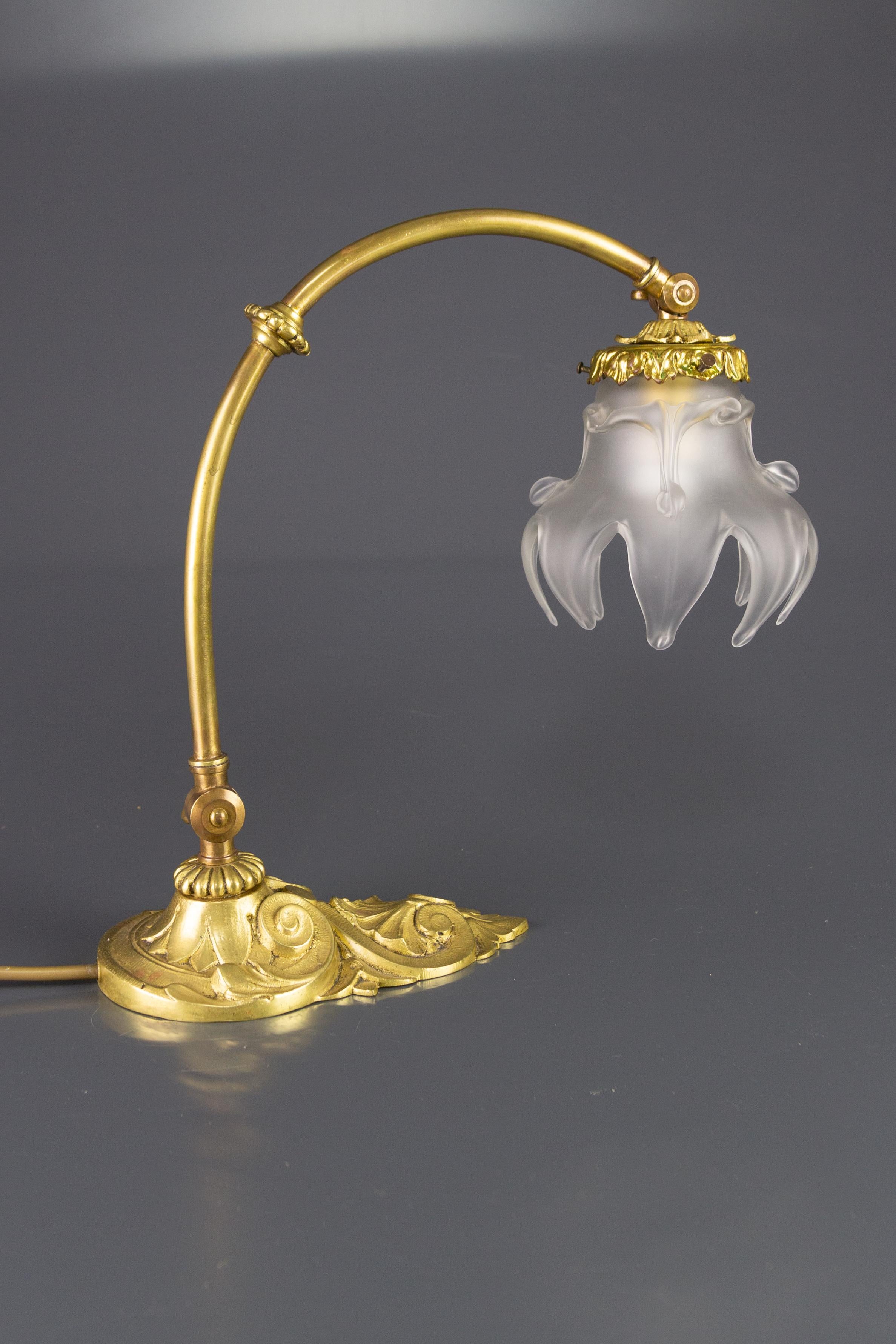 The French Art Nouveau bronze table lamp from the 1930s features a beautifully shaped frosted glass shade and ornate bronze lamp base. The lamp is adjustable in height. Can also be used as a wall lamp. One socket for an E27 (E26) size light bulb. To