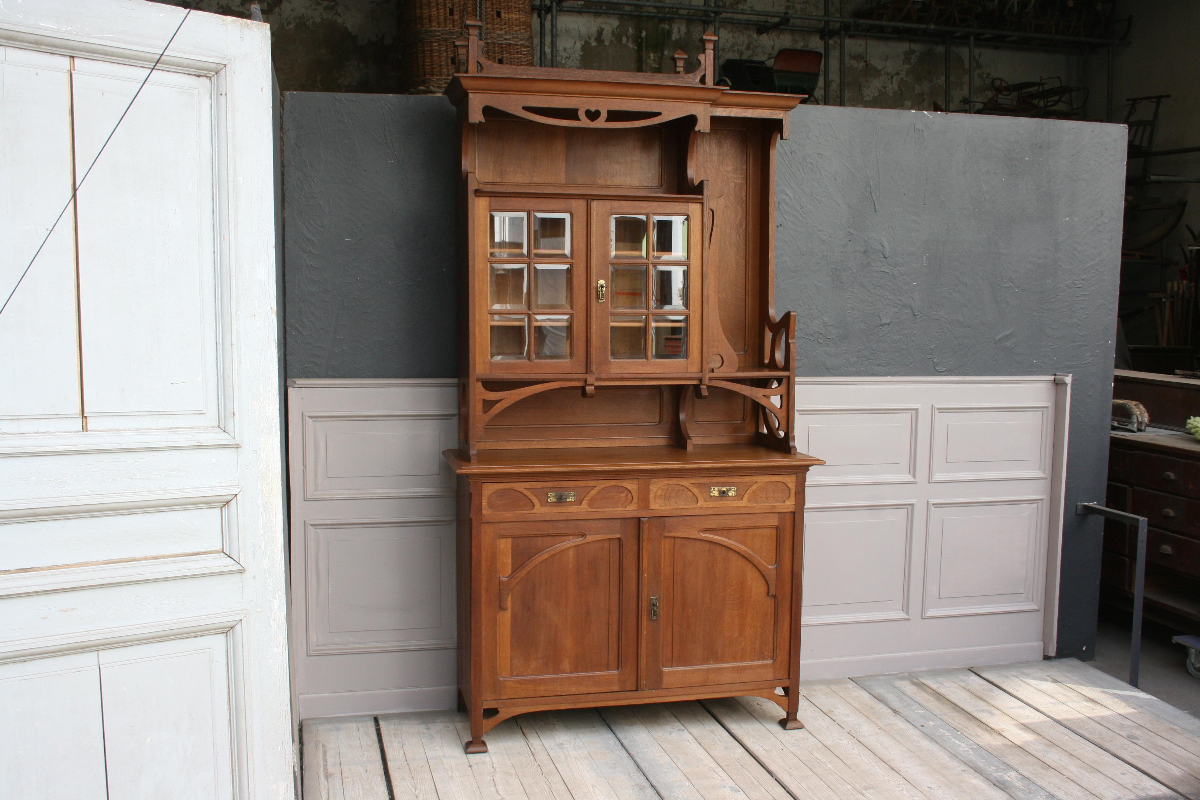 Original Art Nouveau buffet from France from circa 1910. It was made entirely of oak wood and consists of a top and a bottom. The lower part has 2 lockable ornamented drawers, as well as 2 lockable doors with a shelf behind. The top has a unique