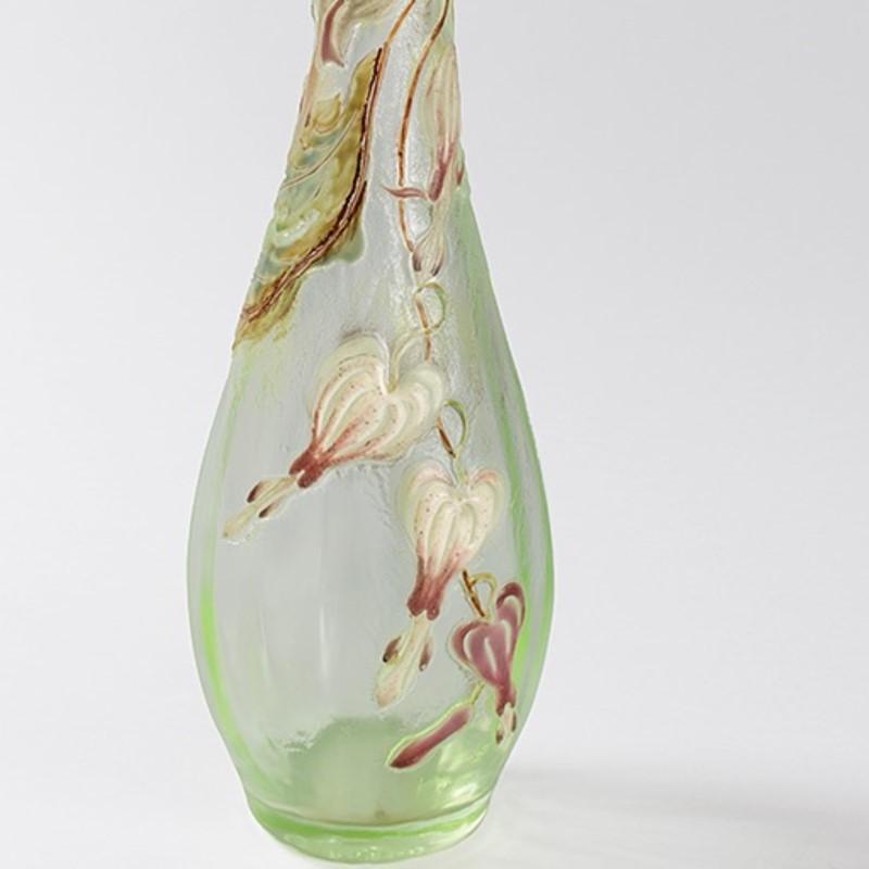 A French cameo and enameled glass vase by Emile Galle?. The vase features bleeding heart flowers with stems and leaves wrapped around and cascading down from the neck of the vase. The decoration is intricately enameled in greens, browns, white and