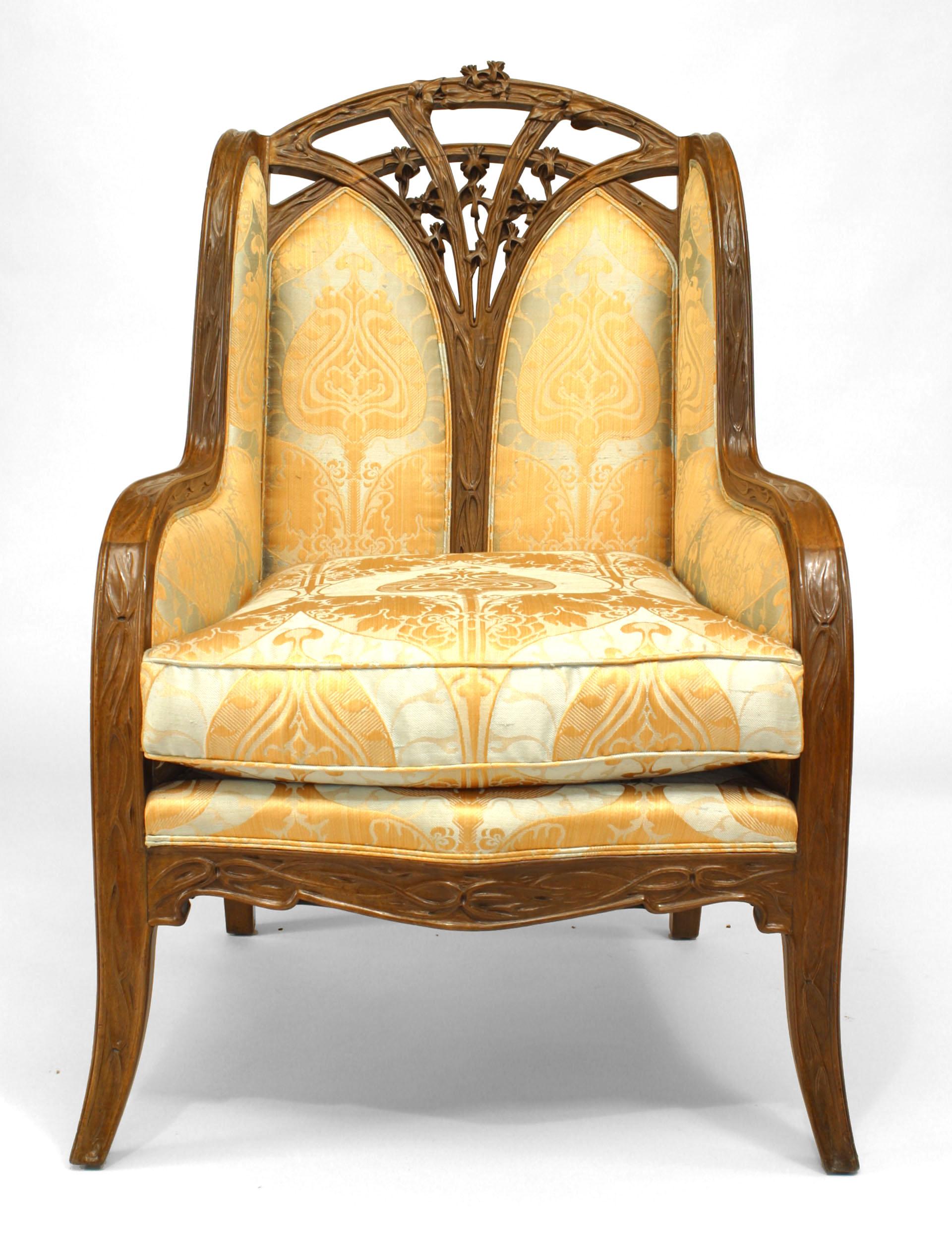 French Art Nouveau walnut bergere arm chair with carved floral trim and filigree back. (LOUIS MAJORELLE)
