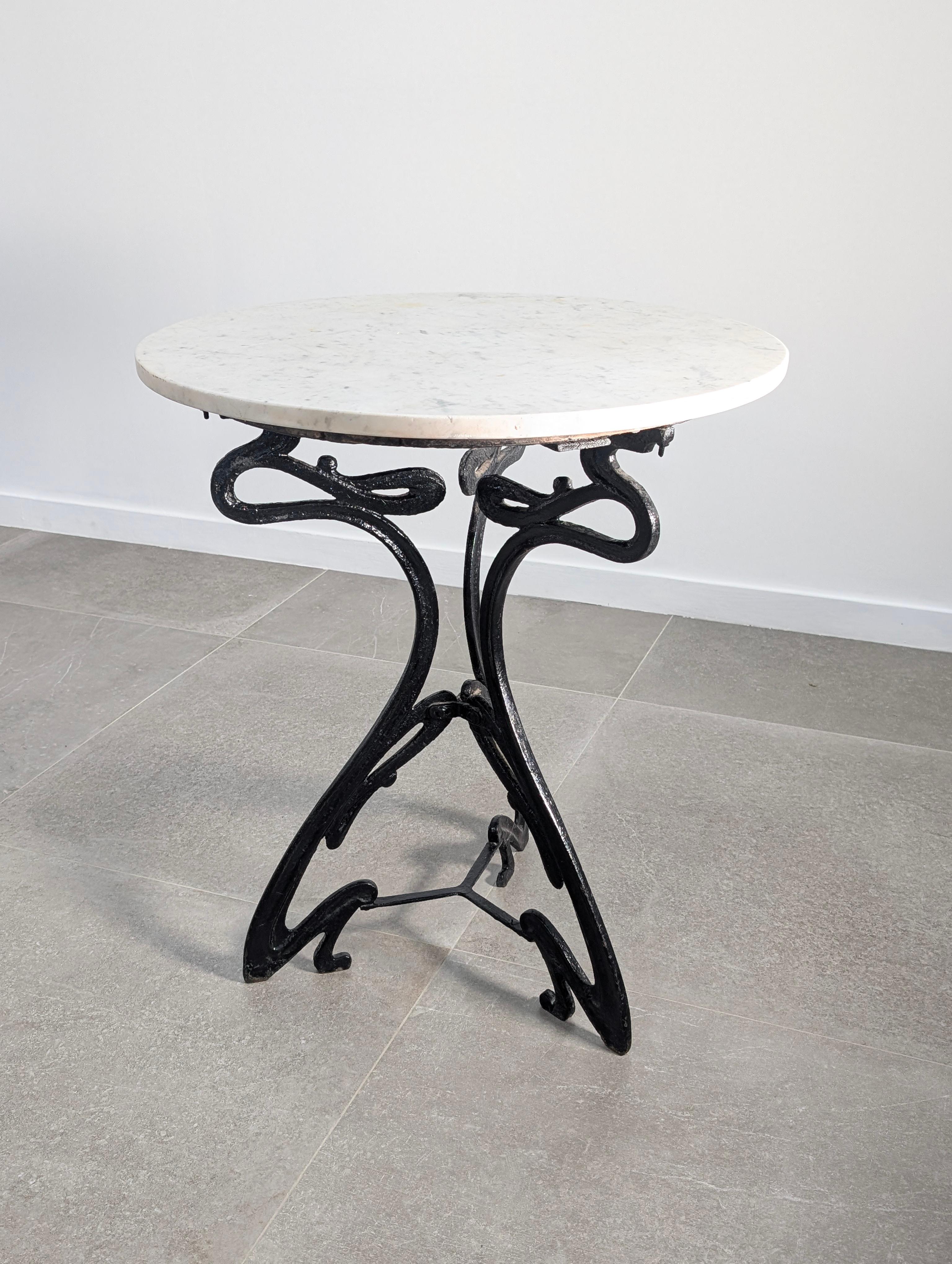 Refined French Art Nouveau table from the early 20th century, featuring a flowing cast iron base with vegetal curves and elegant organic motifs. The table retains its original wooden support surface, originally designed to accommodate a marble top —