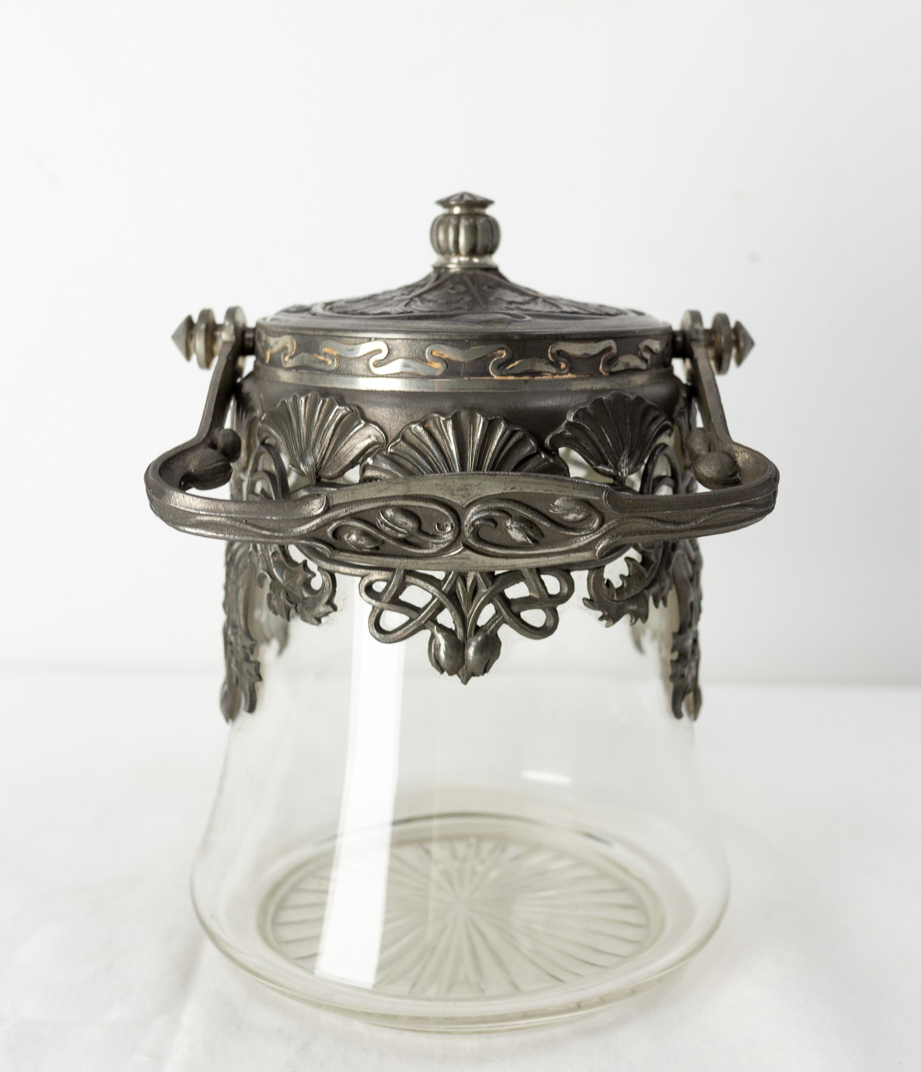 This tin and glass cookies jar is typical of the Art Nouveau period,
during which the designers sought to avoid straight lines while favoring curved lines. Art Nouveau is directly inspired by nature.
French, circa 1900

Shipping:
14 / 14 / 19