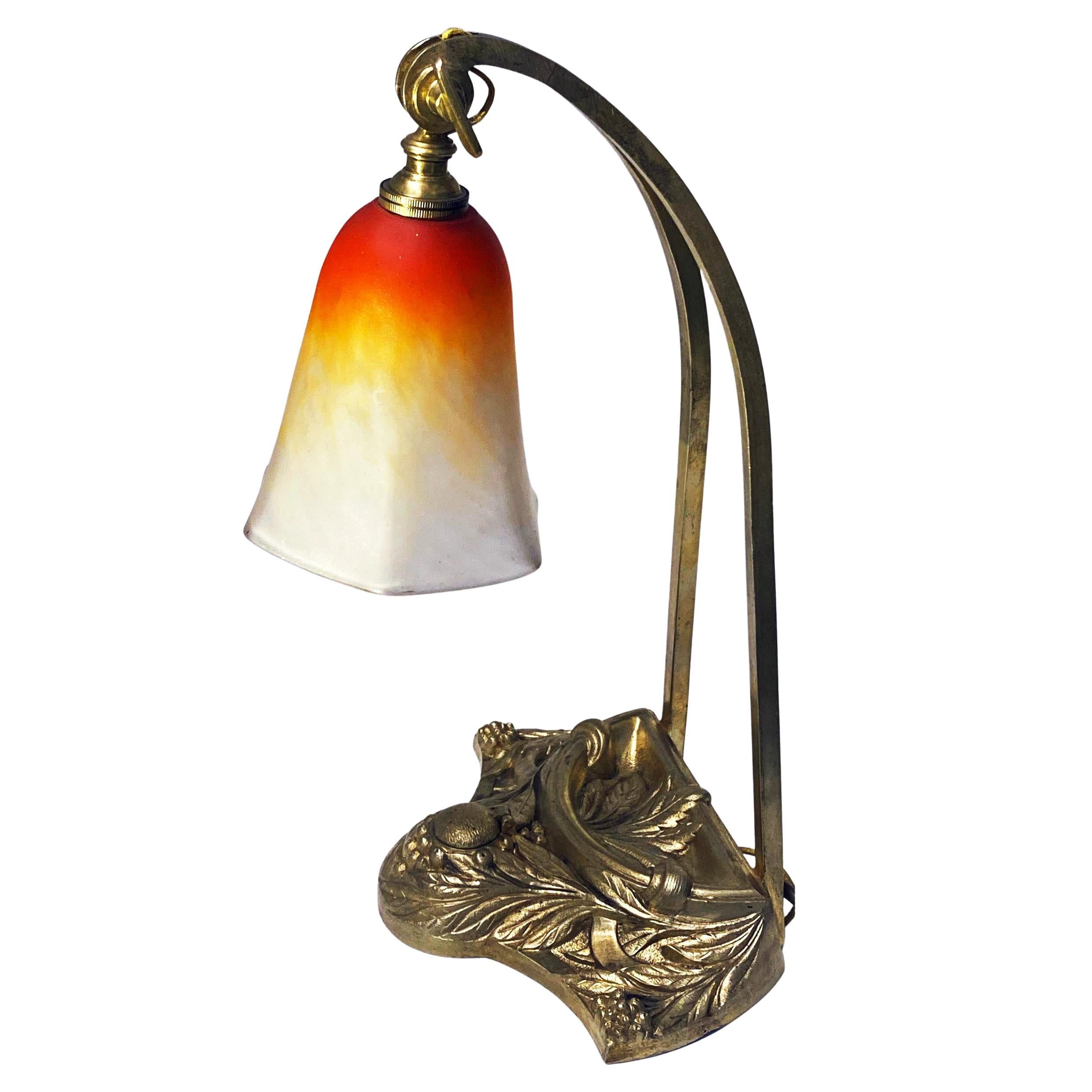 French Art Nouveau desk table lamp by Charles Schneider (Epinay-sur-Seine, Paris), France, C.1920 on stylised bronze base. The base also with concealed opening for an inkwell. The glass shade was made of blown double glass. Measures approximately