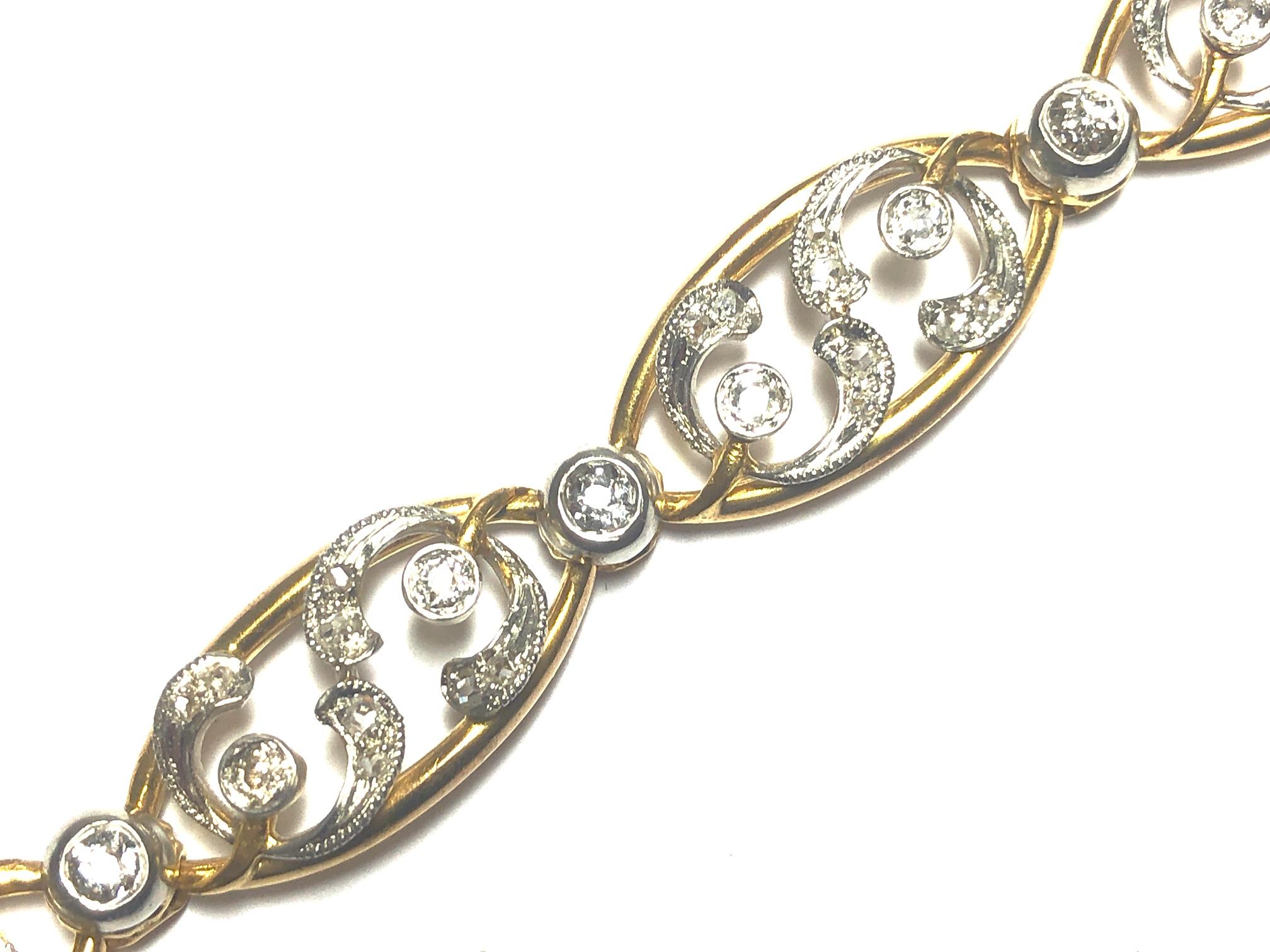 A French, Art Nouveau, diamond and gold mistletoe bracelet, with mistletoe leaves, set with rose-cut diamonds and berries, set with old-cut diamonds, mounted in platinum on open work, navette shaped, yellow gold links, spaced with old-cut diamonds,