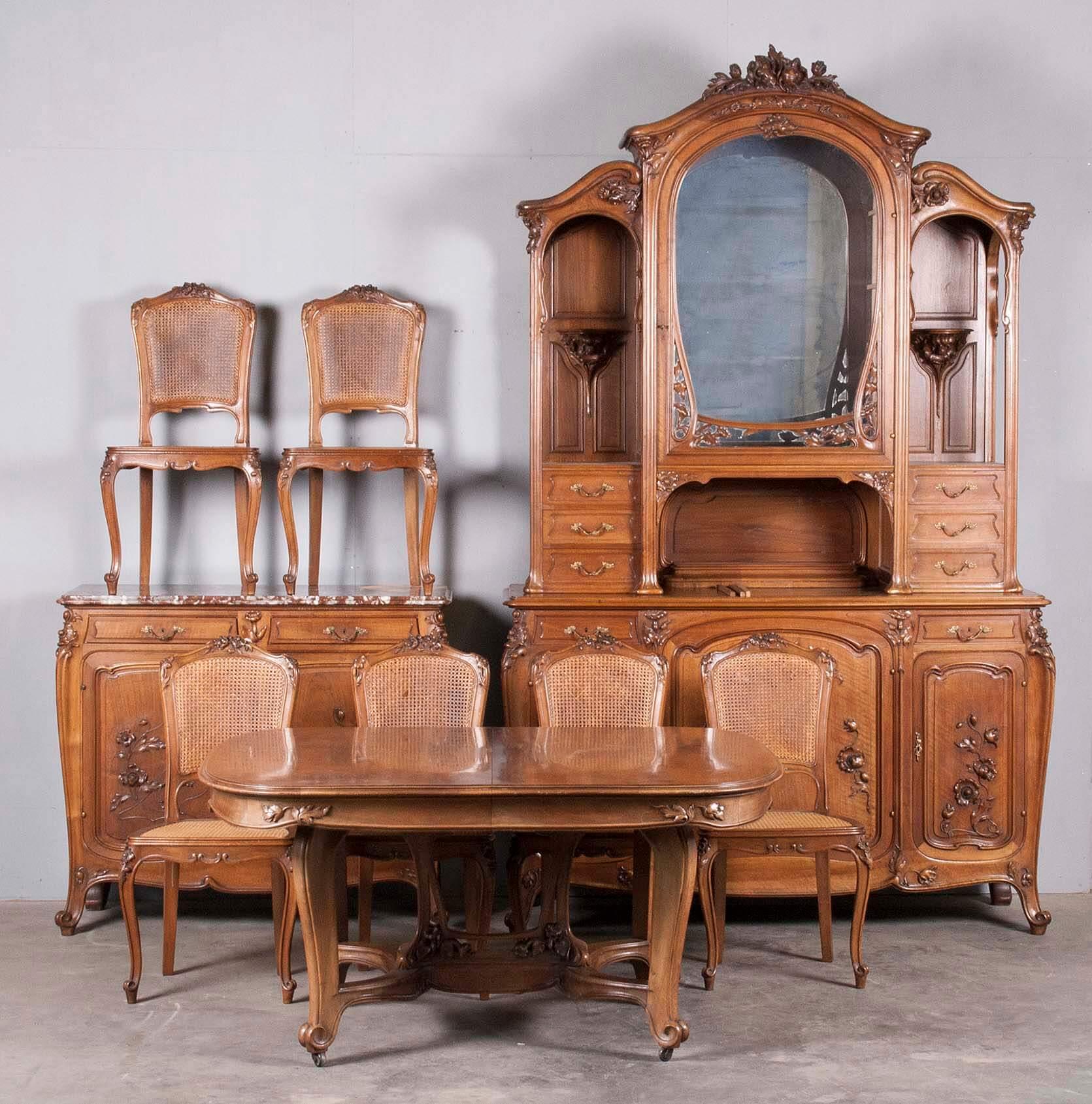 A stunning walnut dining set in Art Nouveau style.
Signed: Eugène Dienst & Fils, France, Paris

Large walnut table. Massive walnut base and burl walnut paneled top.
Decorated with carved flowers. Some stains on the top. 

Buffet cabinet with