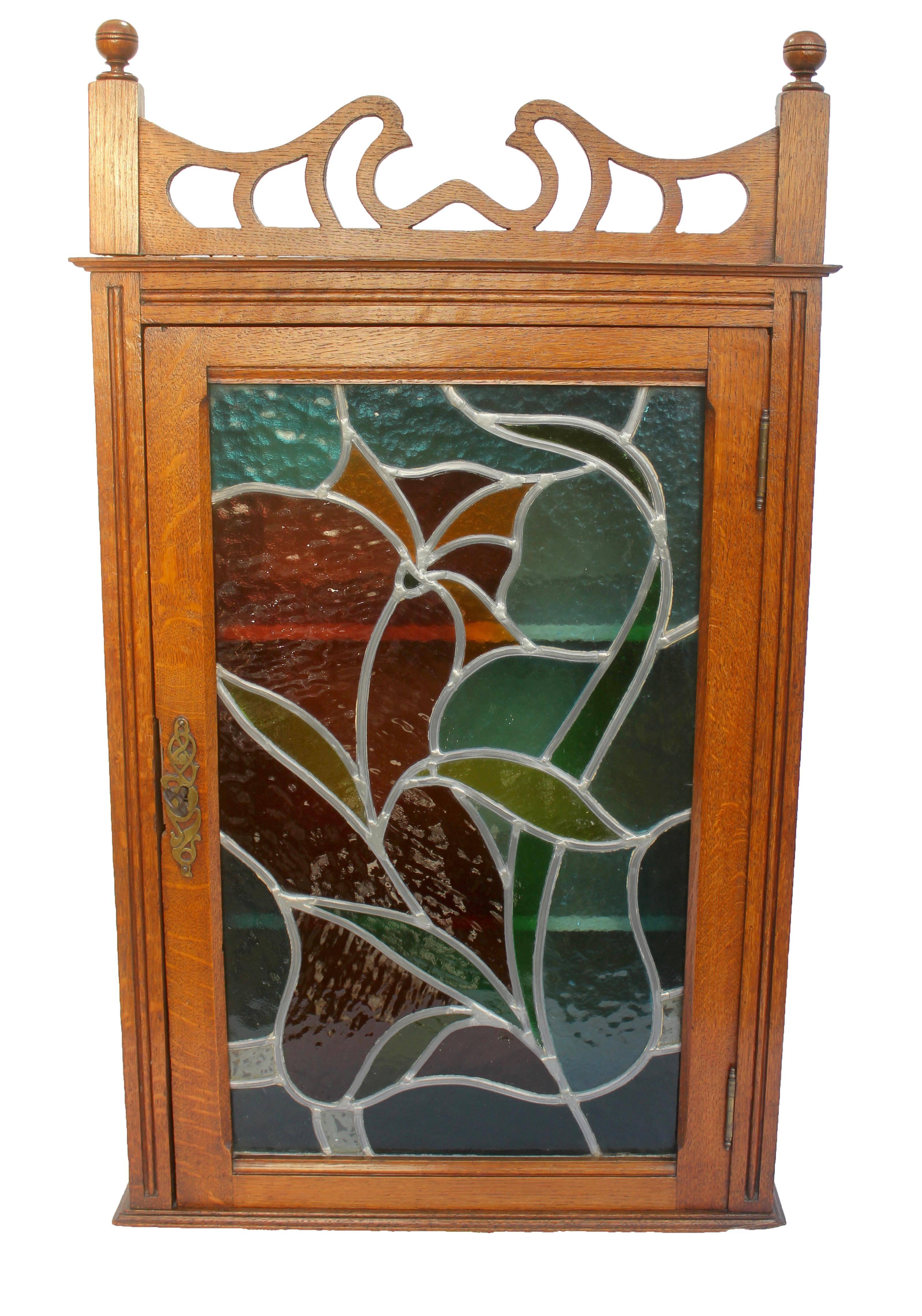 Magnificent French Art Nouveau display case cabinet with colored stained glass in oak. 

This display case cabinet were formerly widely used to keep medications.
There is a small damage on the corner and around the lock see picture please.
In