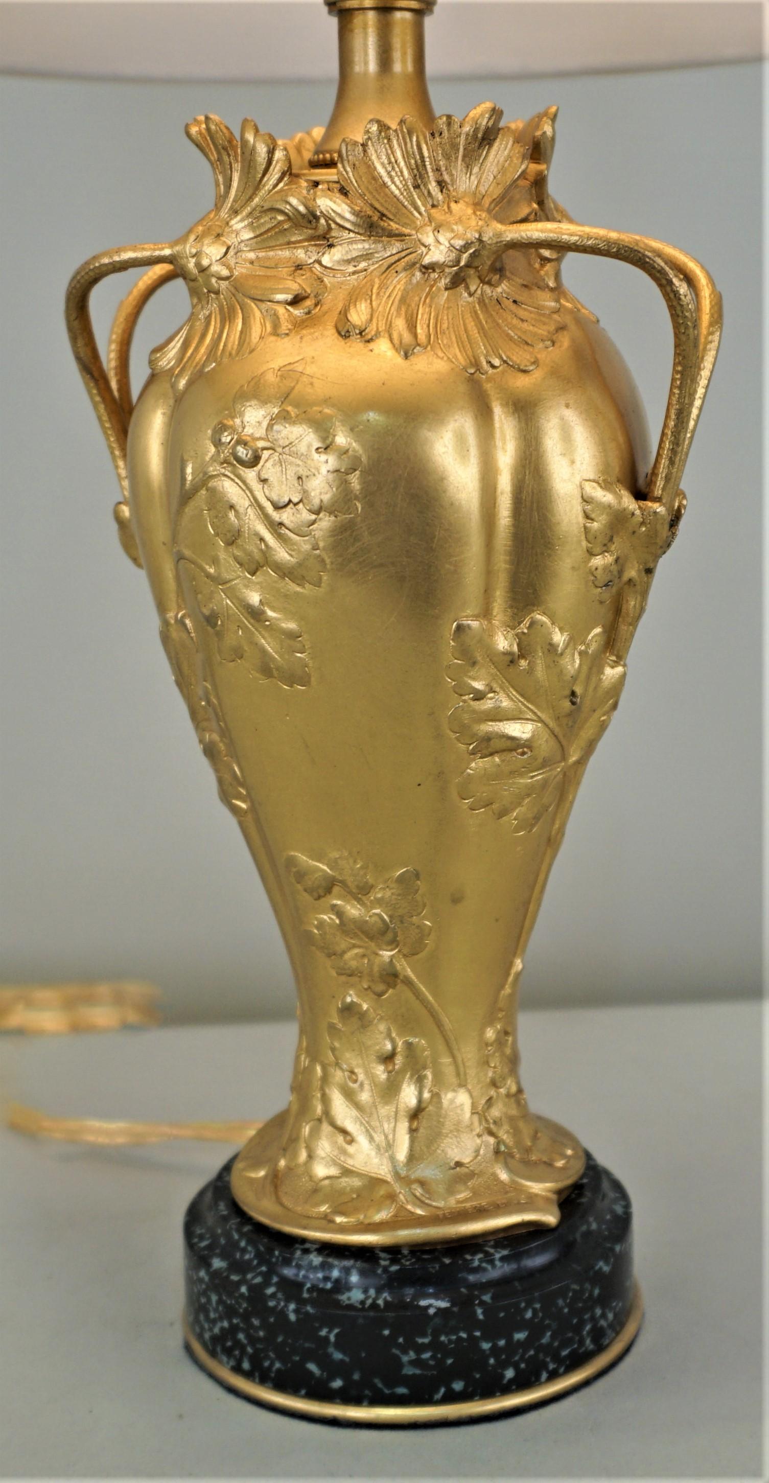 Un vase en bronze doré Art Nouveau qui a été électrifié comme lampe de table et équipé d'un abat-jour en soie.
Ernest Sanglan (sculpture) Fummiere-Gavignot-Thiebaut Freres (fonderie)
La hauteur inclut l'abat-jour.