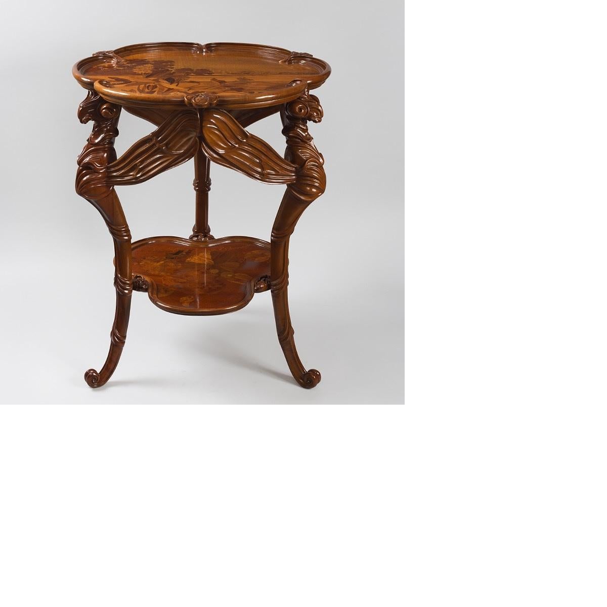 A French Art Nouveau “libellules” two tiered, three legged table with carved and marquetry decoration by Emile Gallé. Each of the three legs of the table is in the form of a dragonfly with extended wings. Each tier of the table is decorated with