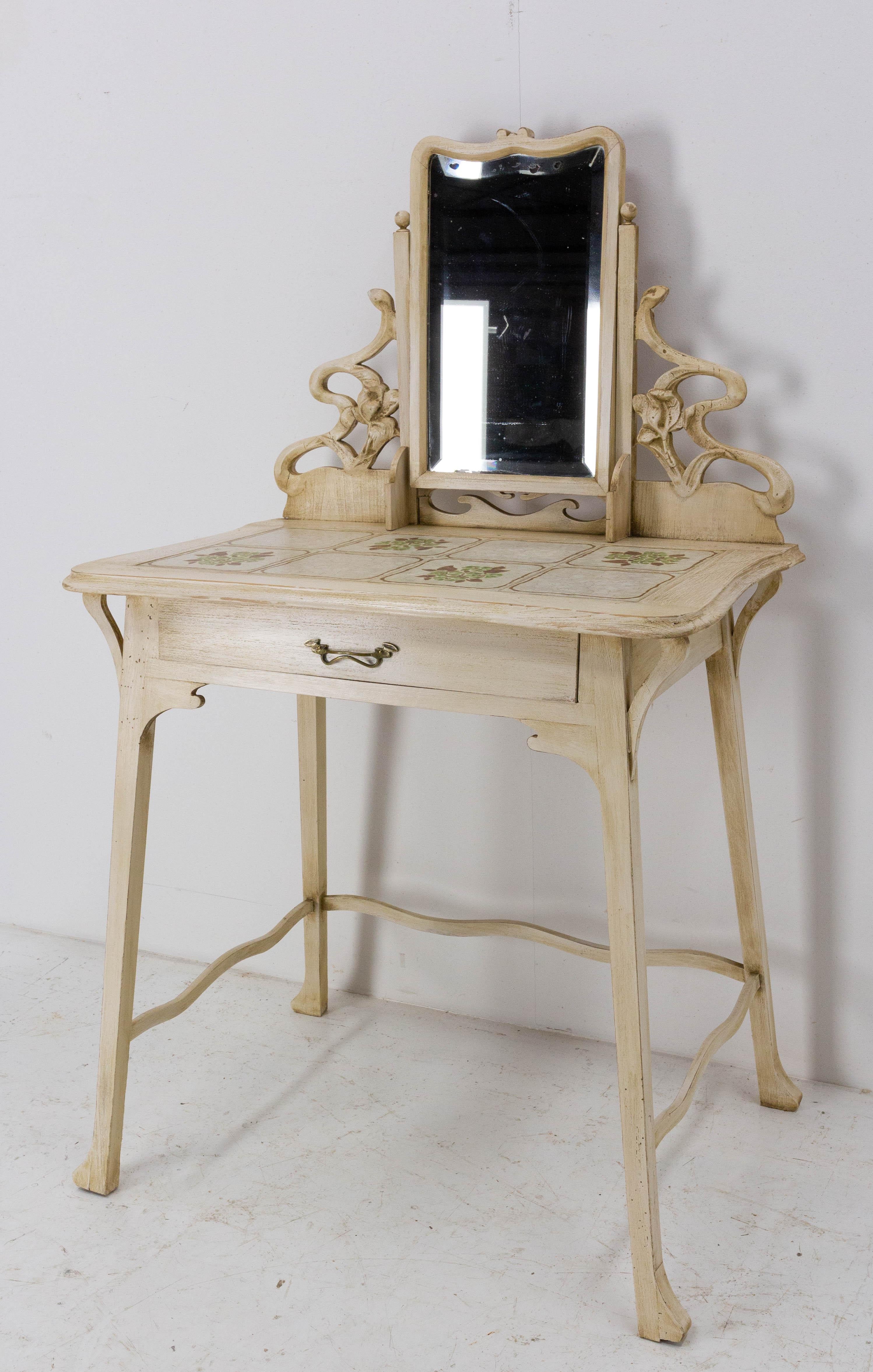 Vanity dressing table with central mirror and one drawer
French late 19th century
Cherrywood, ceramic and beveled mirror. 
All the details of this vanity table are typical of Art Nouveau: the shape of the feet, the wavy side bars, the vegetal and