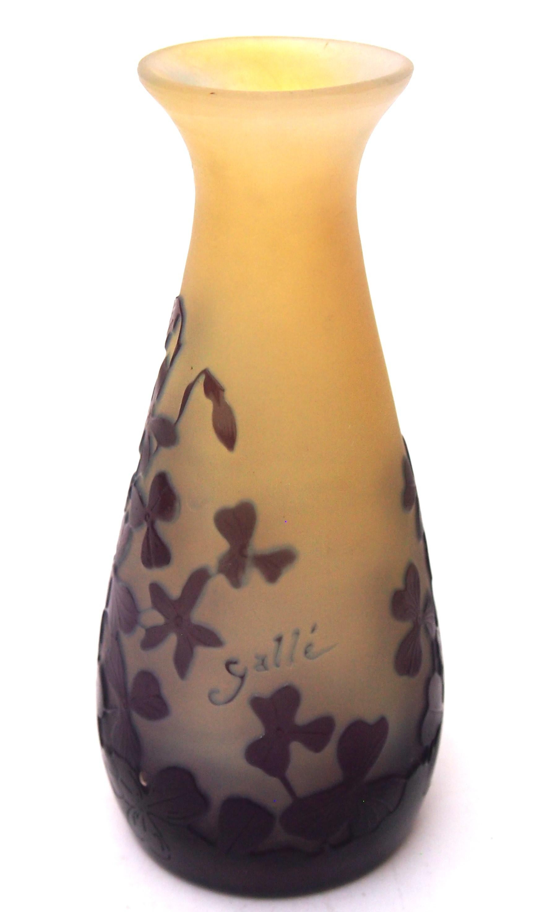 A particularly pretty small Emile Galle Cameo glass vase in a slightly tapered cone shape with larger flared lip - It is In a striking colourway of purple over blue over yellow-orange, it depicts delicate violets or a violet like blooming flowers.