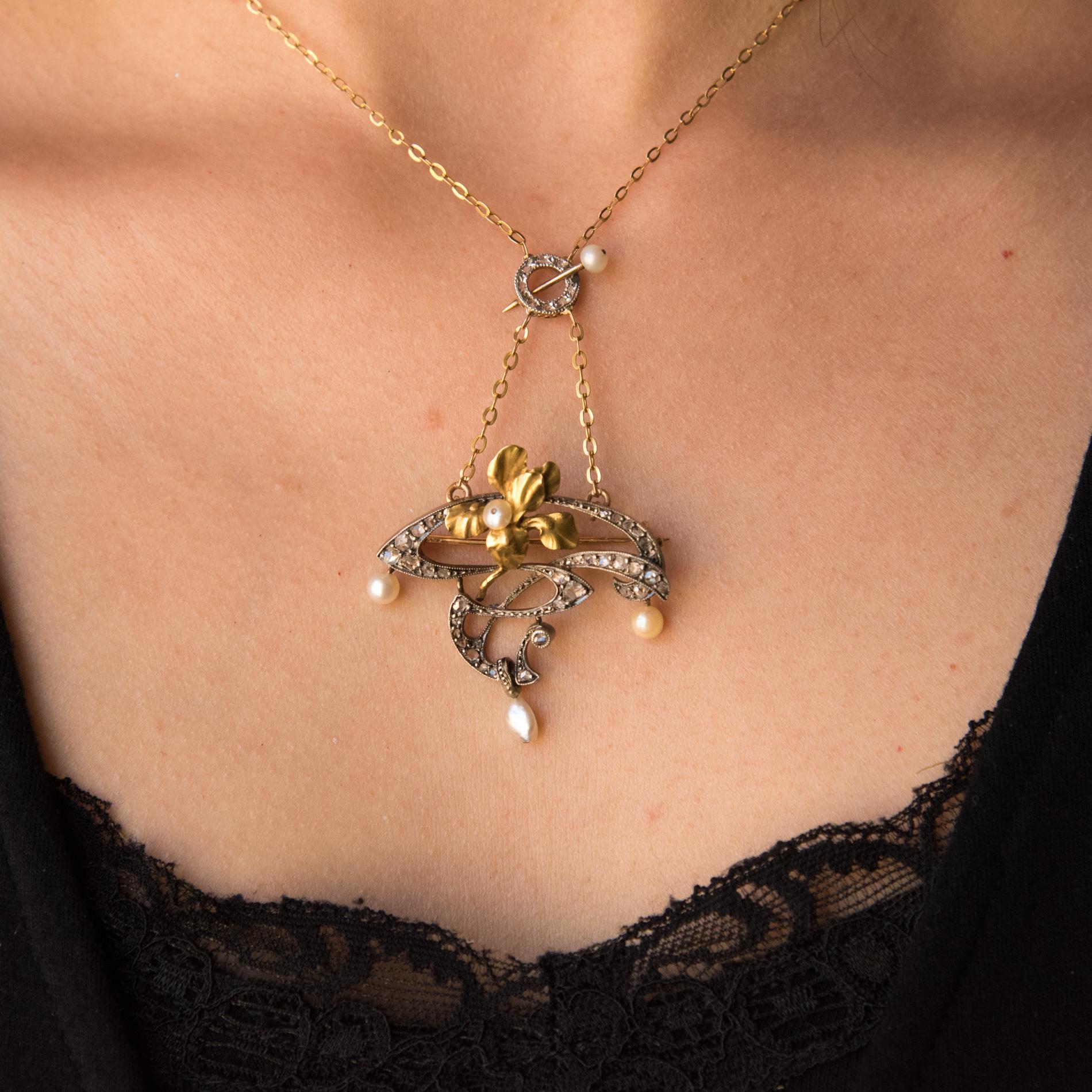 18 carat yellow gold and silver necklace eagle's head hallmark.
Featuring an openwork floral design set with rose cut diamonds. The necklace features a yellow gold Iris motif set with a fine flat pearl. Suspended from the pendant are 3 white beige