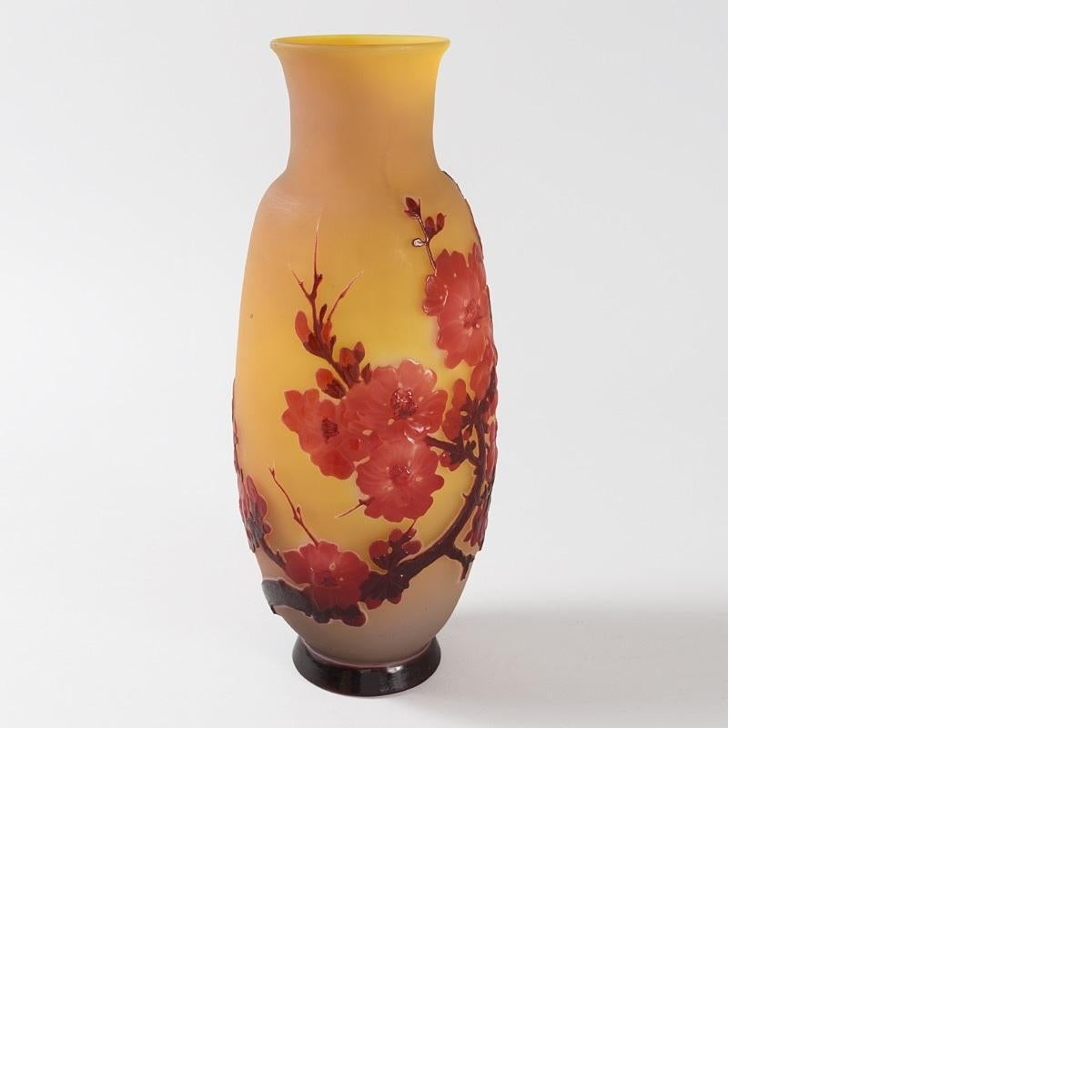 A French Art Nouveau 'Fleurs de pommier' cameo glass vase by Émile Gallé. This ovular vase features crimson leaves and crisp red apple blossoms on a gold ground. The flora are rendered in slightly translucent glass, which makes a remarkable contrast