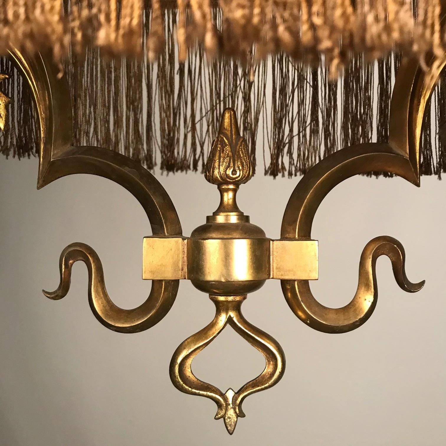 This unusual hanging fixture much evokes a fin de Siecle sensibility. The four scrolling arms with flower form frosted shades are on downswept gas tubes now altered for electricity. The central cluster is mounted with an hexagonal shade formed with