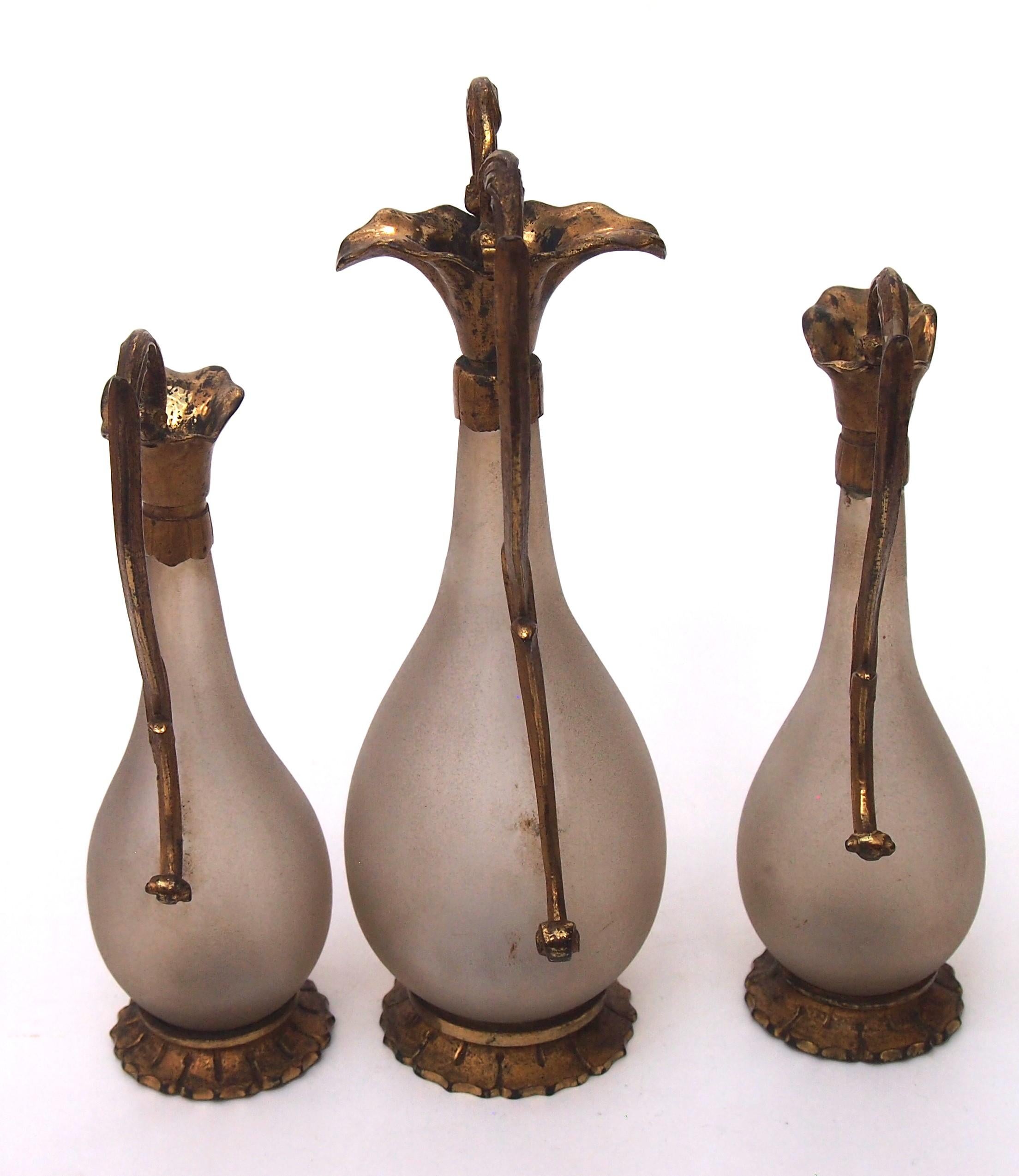 Un'elegante guarnitura d'epoca in stile Art Nouveau francese in vetro smerigliato e metallo di base, composta da un vaso centrale a goccia con base e parte superiore in metallo ornata da lunghi manici sinuosi che penzolano su ciascun lato (il vaso