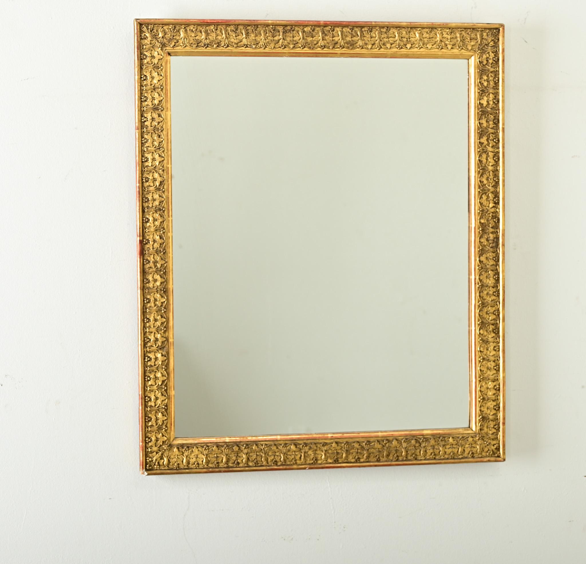 Bellissima specchiera di fine secolo (circa 1900) in stile Art Nouveau francese, dorata su intonaco modellato con un disegno ripetitivo di edera. La cornice rettangolare mostra un motivo fogliare a basso rilievo che raffigura una pianta di trifoglio