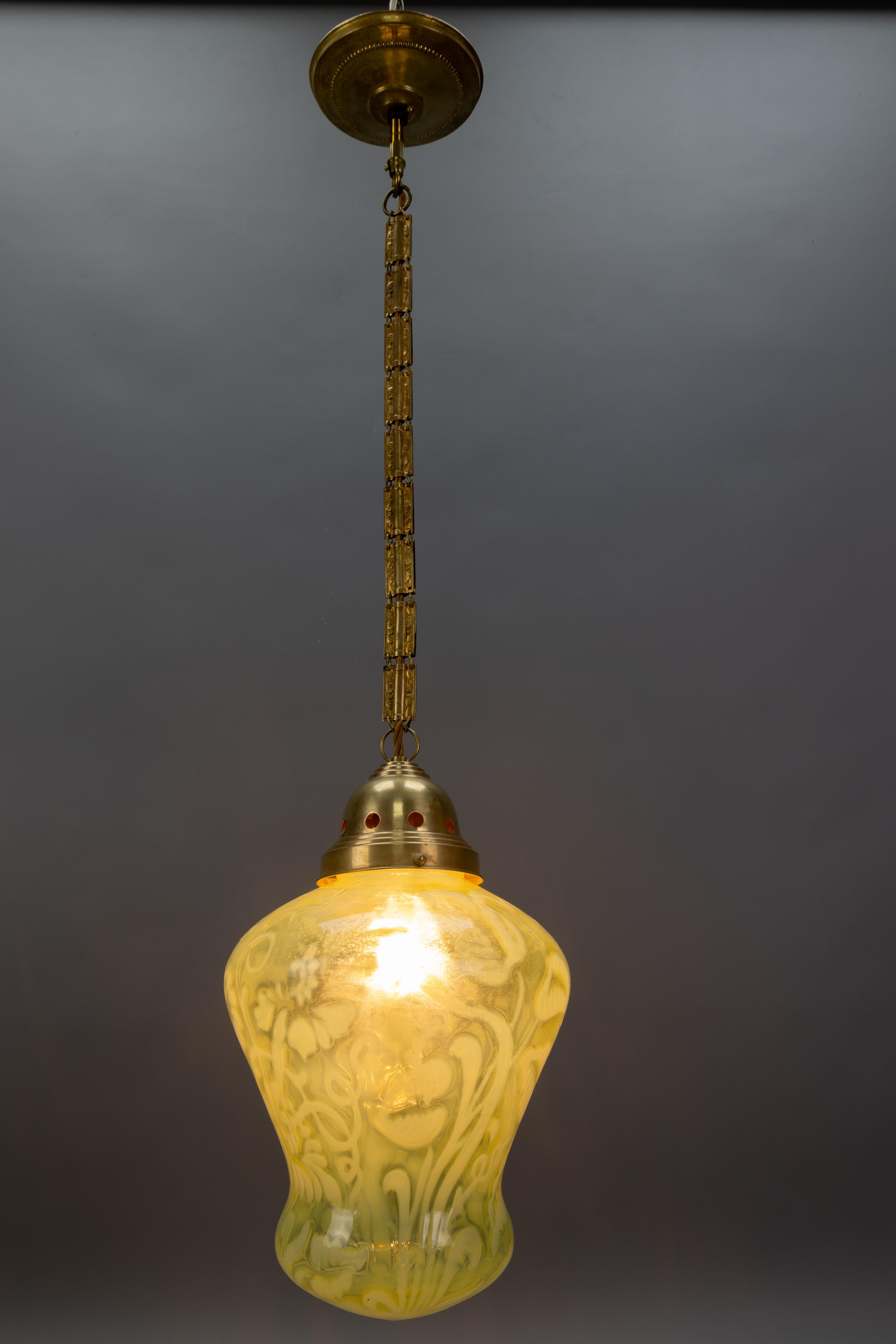 Lampada a sospensione in vetro vaselina verde Art Nouveau francese con catena in ottone decorata, circa 1920.
Un'elegante lampada a sospensione francese in stile Art Nouveau, risalente al 1920 circa, presenta un paralume in vetro soffiato a mano