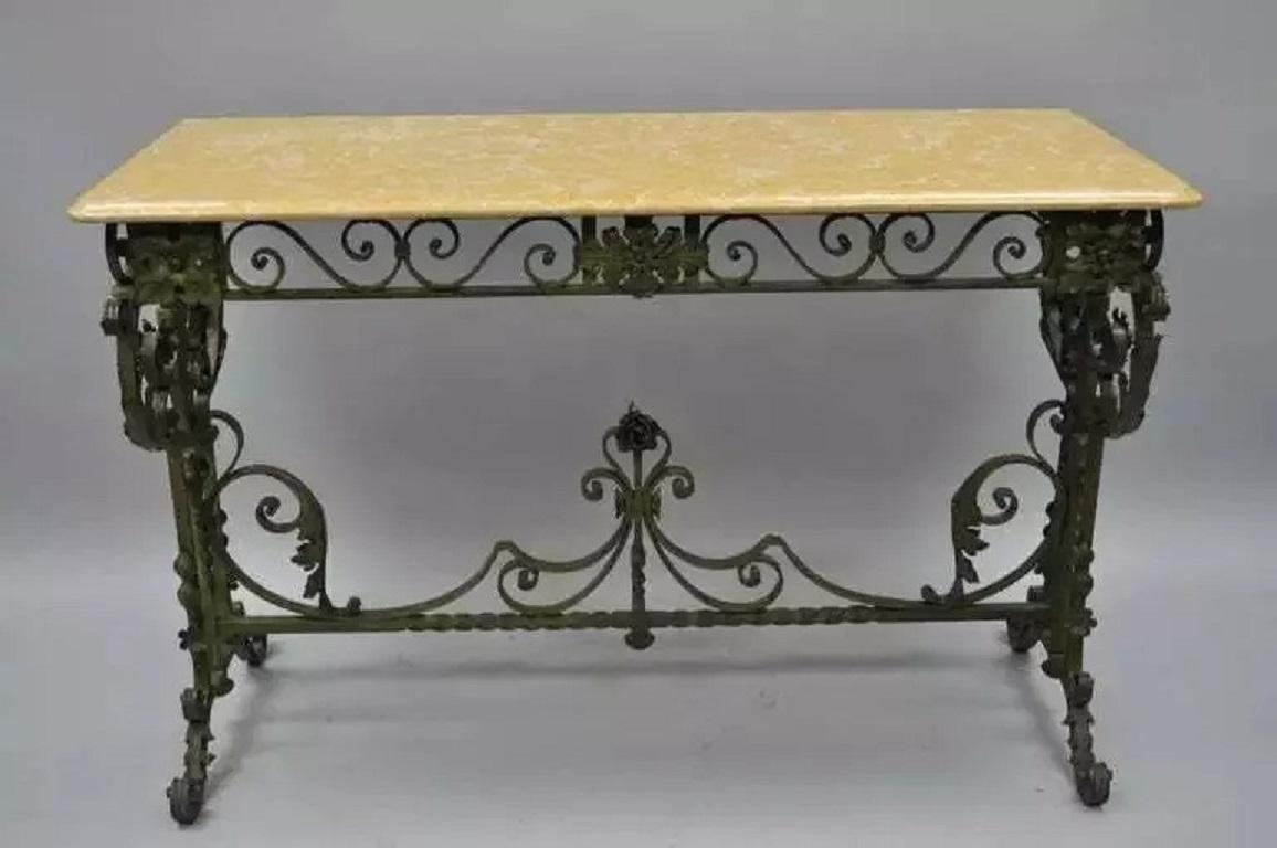 Antique French Art Nouveau Green Wrought Iron Marble Top Scrolling Console Hall Table. Item features a patinated green scrolling wrought iron base with ornate floral work and stretcher support. The yellowish tan marble top features a beveled edge