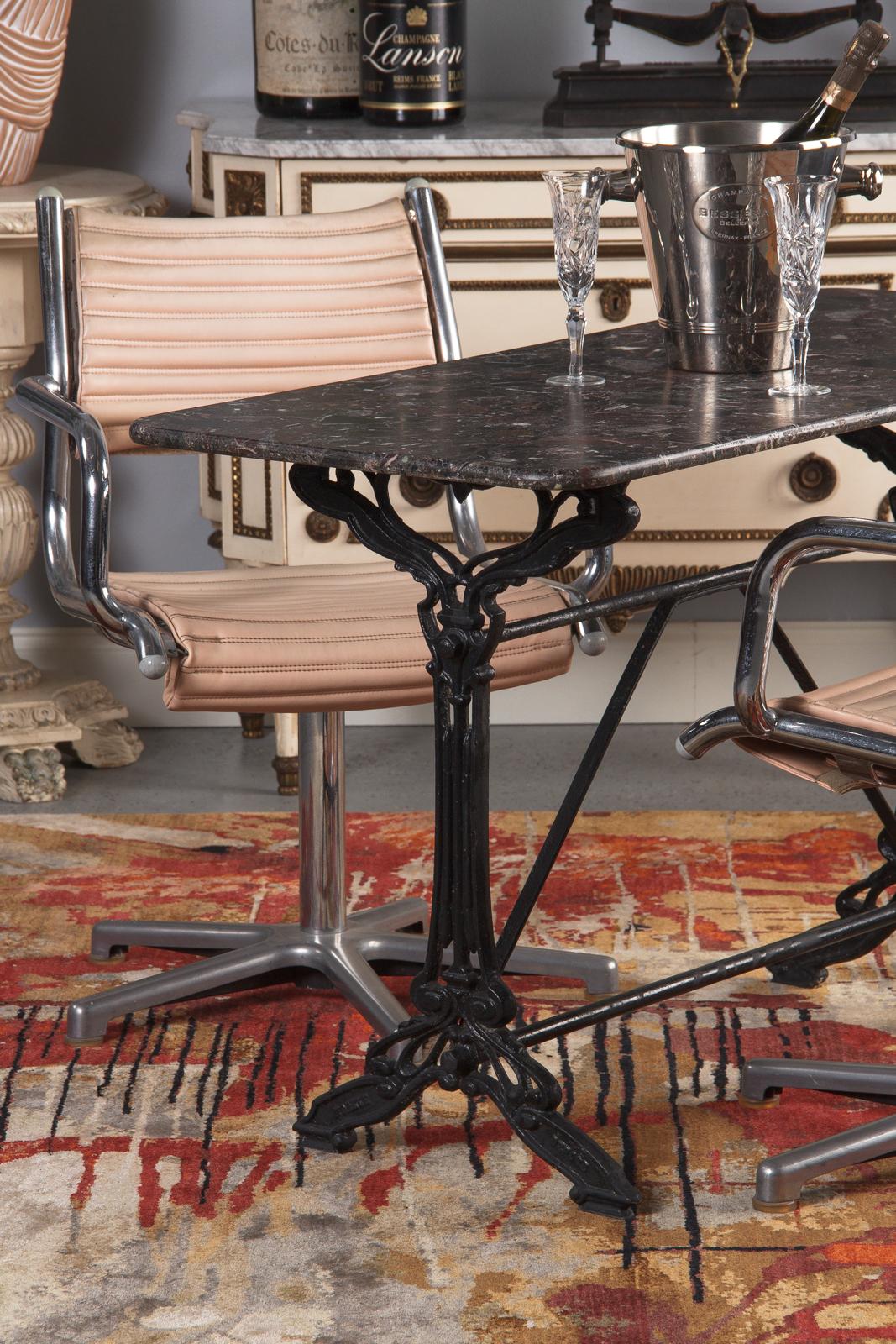 A distinctive Art Nouveau iron bistro table with purple marble top, French circa 1900. Painted forged iron base, floating marble top. The legs have Classic Art Nouveau styling, with looping scrollwork and sinuous lines. An encircled star graces the