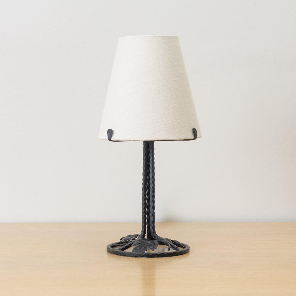 Incredibile e unica lampada da tavolo francese Art Nouveau in ferro. Corpo in ferro forgiato con dettaglio di foglie fluttuanti su una base circolare in ferro. Appena ricablato e con un nuovo paralume in lino affusolato. Il ferro è stato verniciato