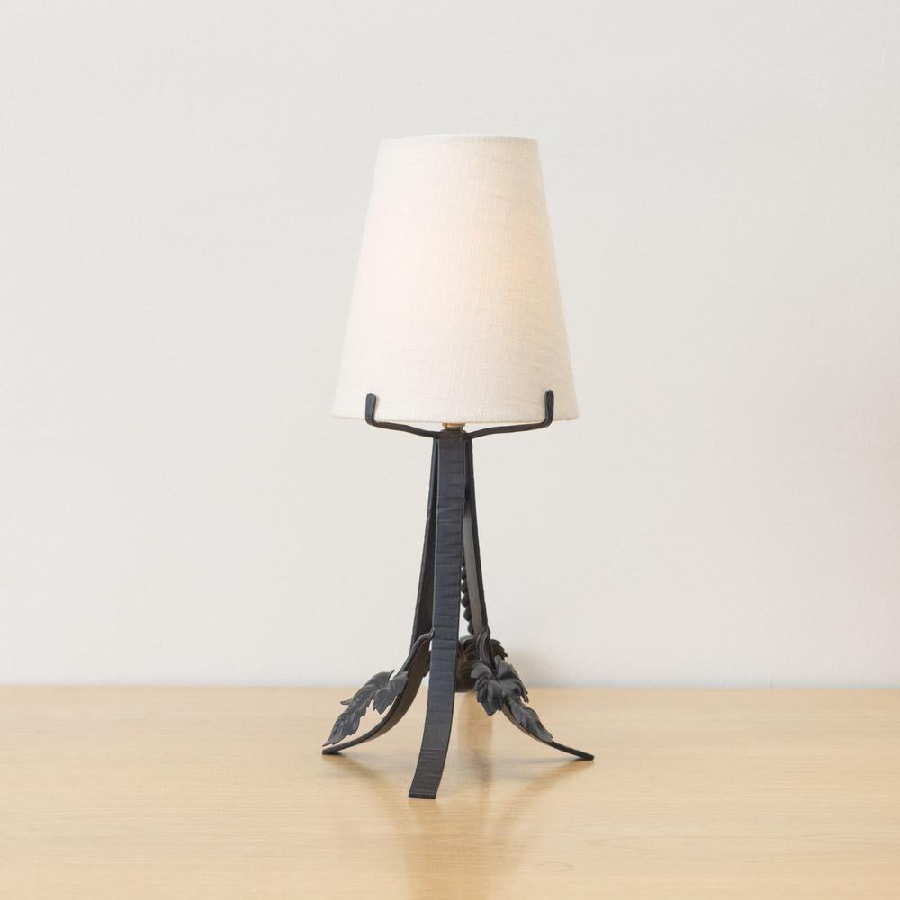 Incroyable et unique lampe de table en fer Art Nouveau français. Corps en fer forgé avec détails de feuilles flottantes sur une base en fer tripode. Câblage refait à neuf et nouvel abat-jour en papier effilé. Le fer a été récemment recouvert d'un