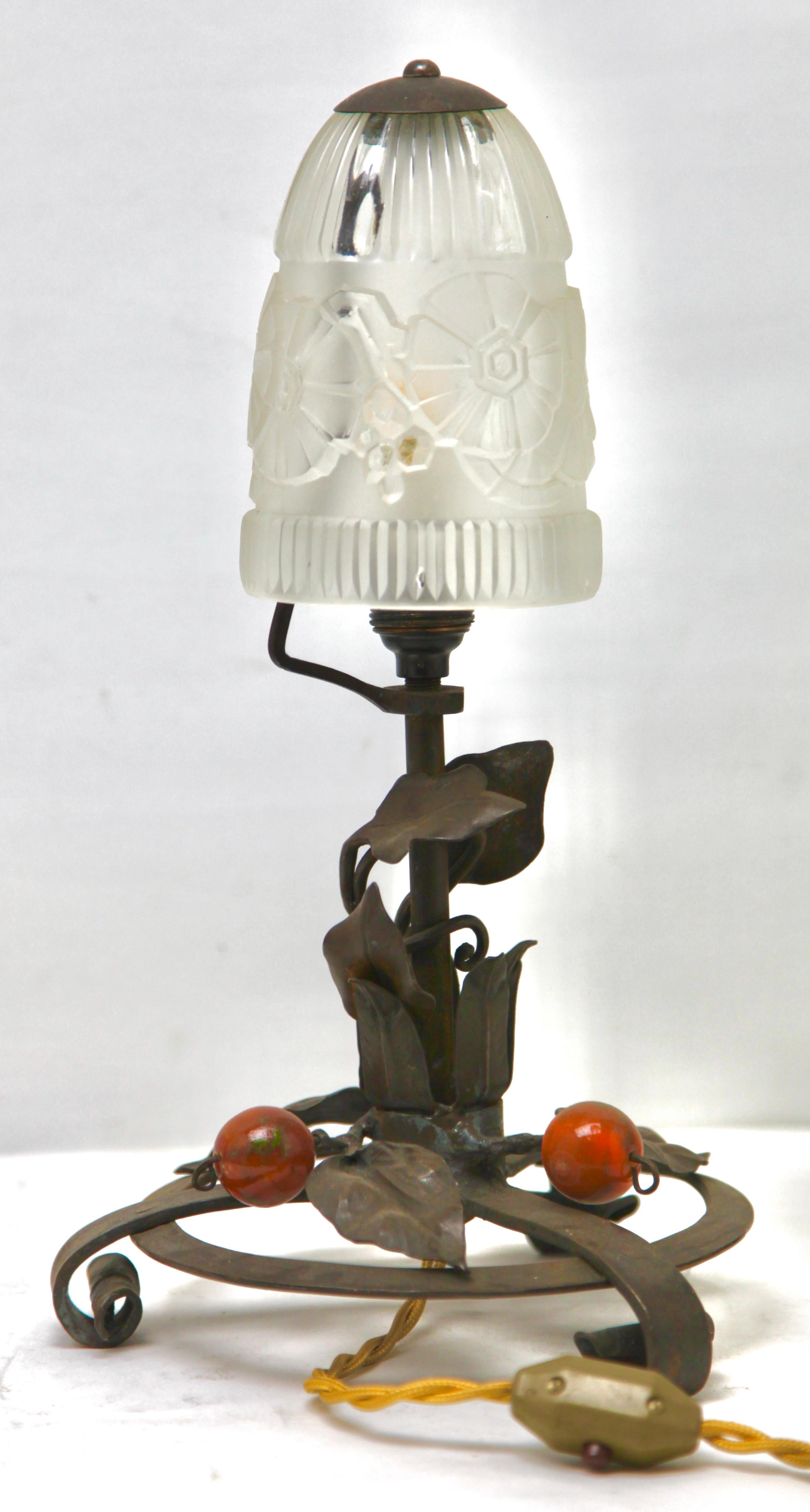The 1920s, France
A wonderful French Art Nouveau lamp. The stands are handmade in wrought iron with black finish patina and hammered with a floral pattern. The metalwork is of excellent quality.
Crowned with bright shade in Molded glass.
In