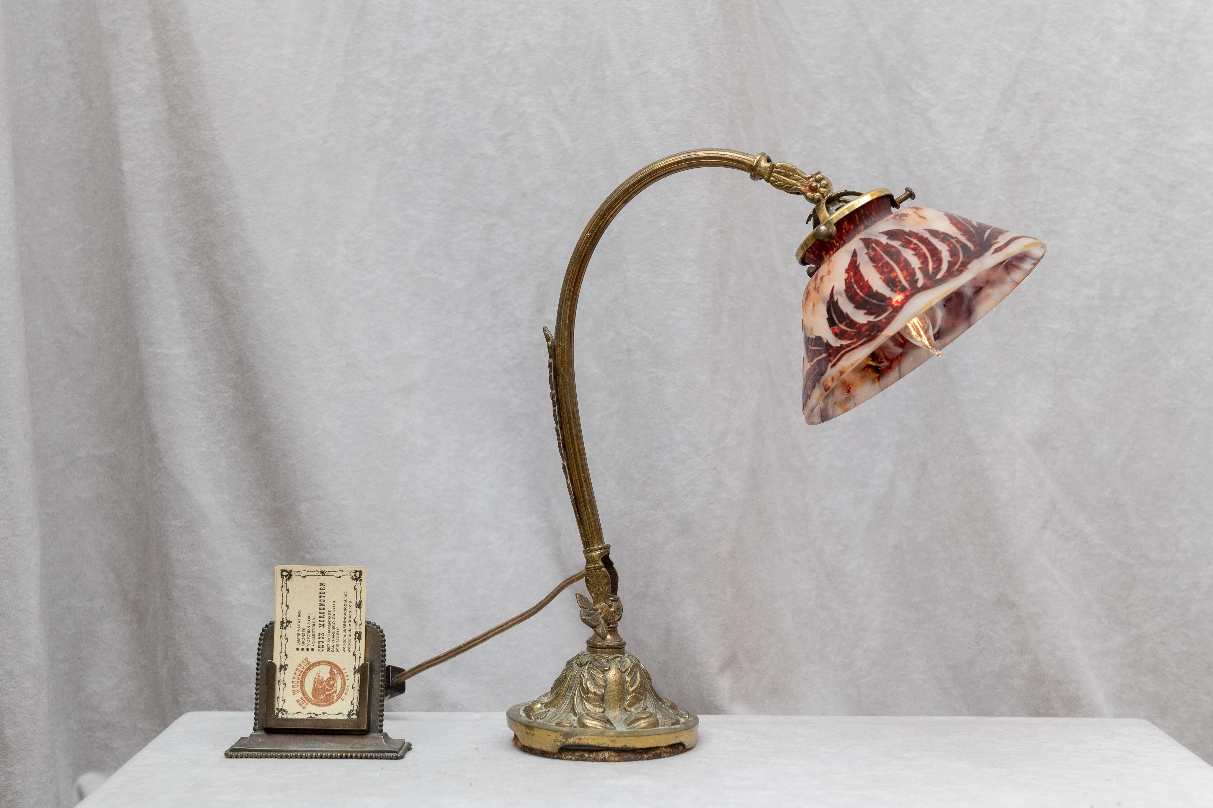 This sweet little desk lamp has the great Art Nouveau look. The bronze base and colorful cameo glass shade make a fine package. Cameo glass is a very complex and skillful art. 2 layers of glass are joined and then the top layer is carved away to