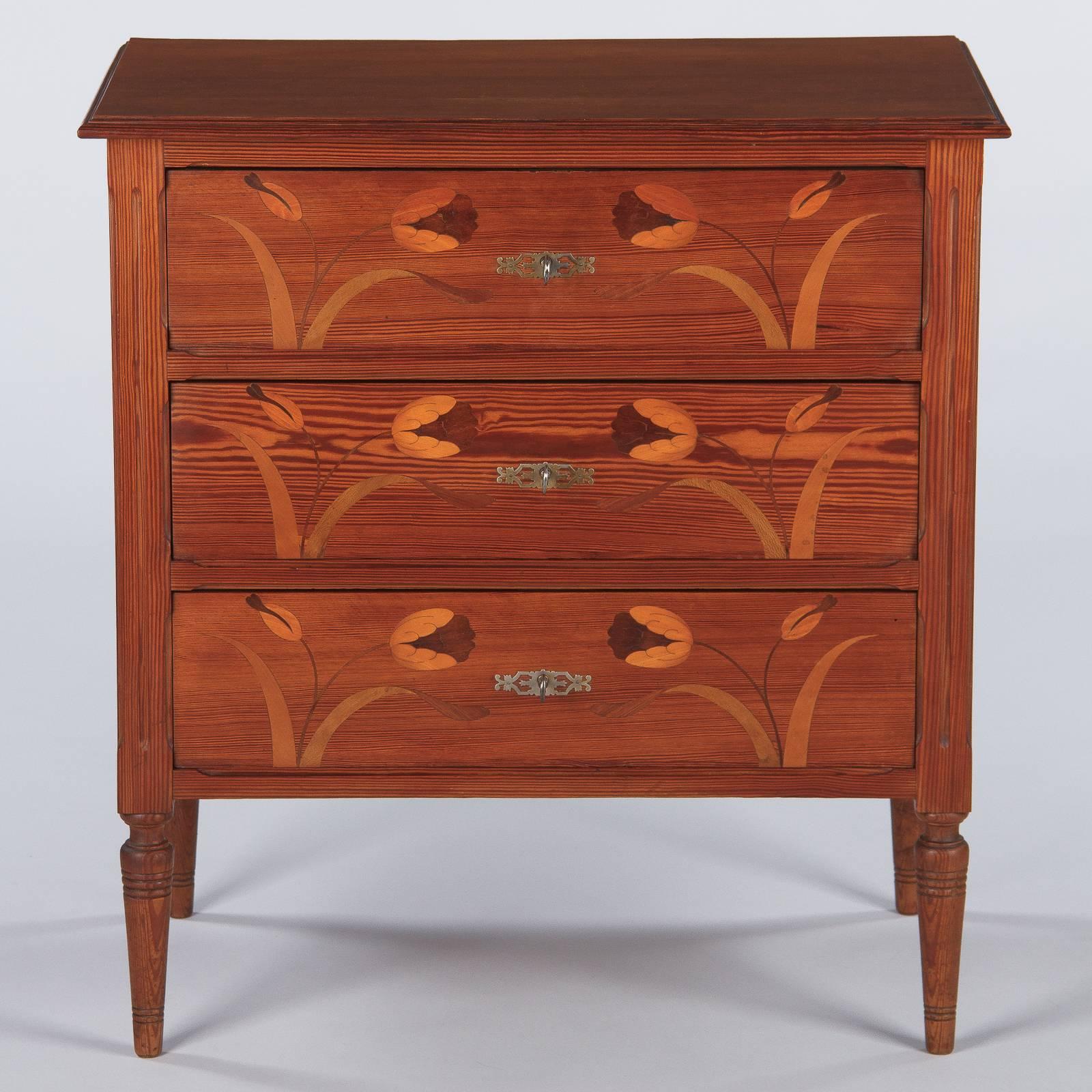 A very fine Art Nouveau inlaid chest of drawers in pitch pine, French, circa 1900. This piece features stand-out inlay on the drawer fronts, as well as the panelled sides. Elegant and very tight inlaid fruitwoods form delicate tulips, with full