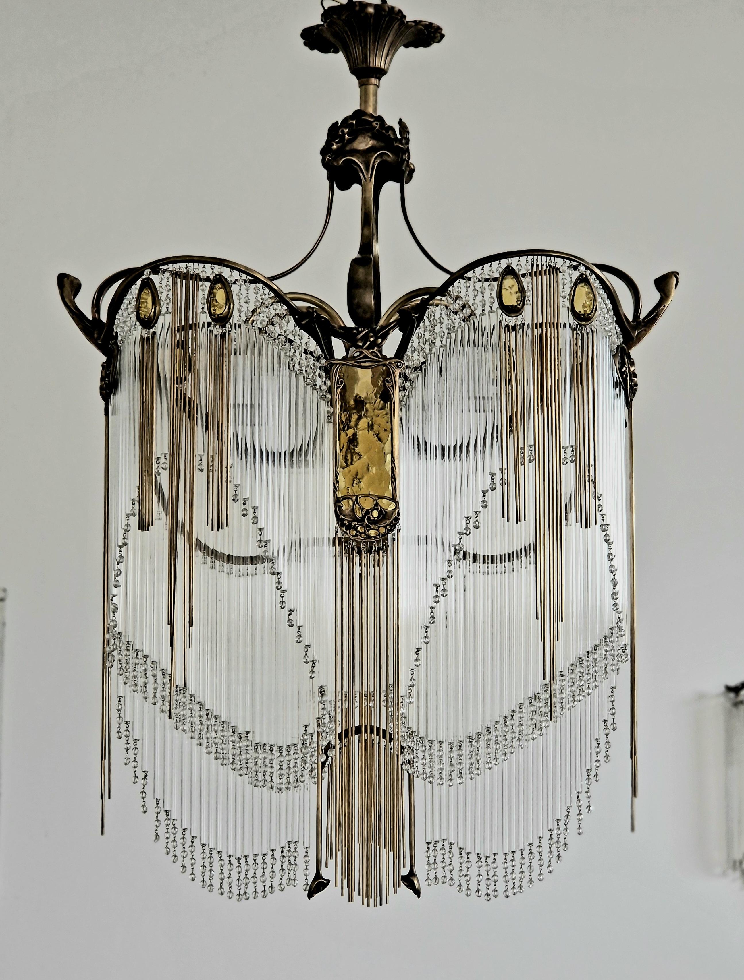 Lampadario Art Nouveau in bronzo di Hector Guimard con finitura in bronzo antico e pate de verre color ambra.
    