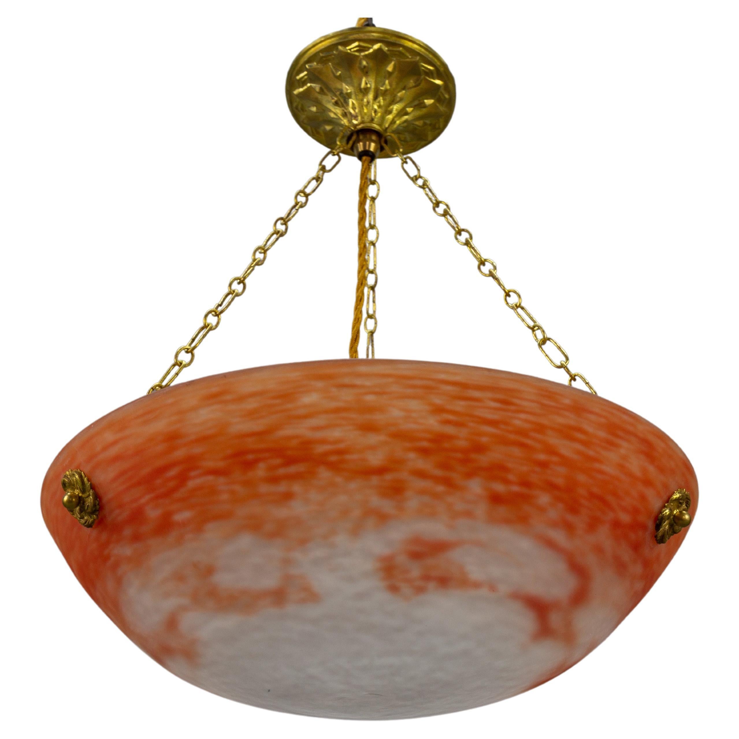 This adorable French Art Nouveau period pendant chandelier features a mottled “Pâte de Verre” art glass bowl in orange and white color, signed ”Noverdy France” by Jean Noverdy. The pendant light fixture has three chains attached to the glass bowl