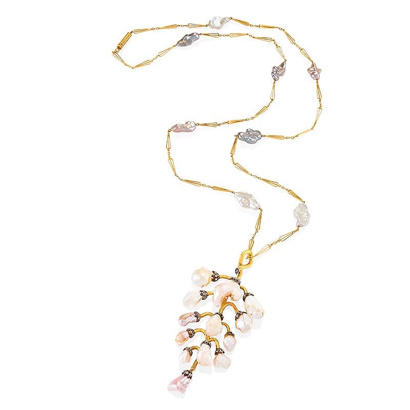 Composed of freshwater pearls with silver and rose tones, highlighted by rose-cut diamonds, this Art Nouveau gold pendant necklace dates from circa 1900, and is offered with a later-added gold and pearl chain. The gently articulated form is designed