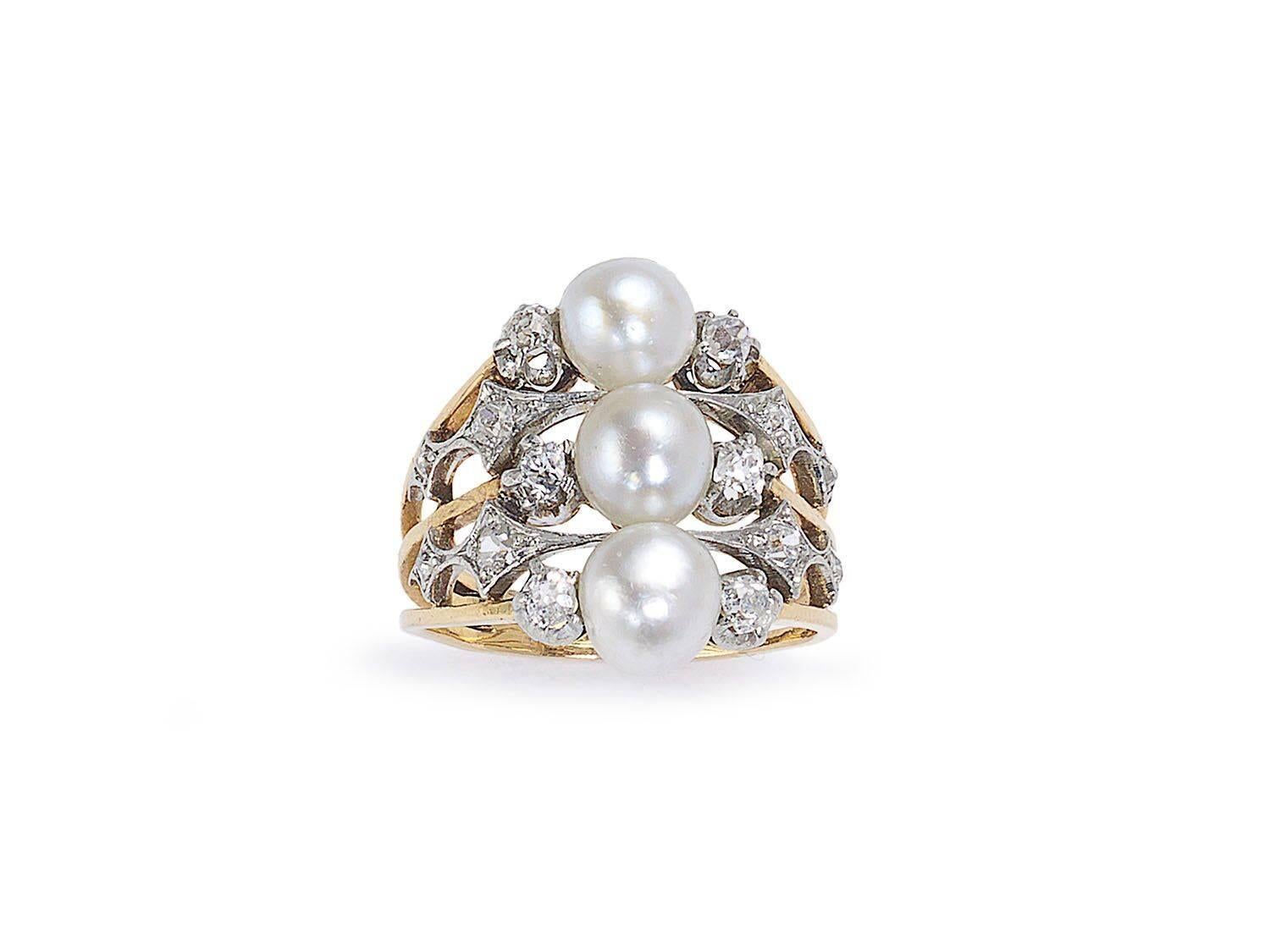 A French Art Nouveau pearl and diamond ring, set with three natural pearls, measuring approximately 6mm each, with old-cut diamonds set either side, with four more diamonds in openwork, Art Nouveau design shoulders, in platinum settings, on a three