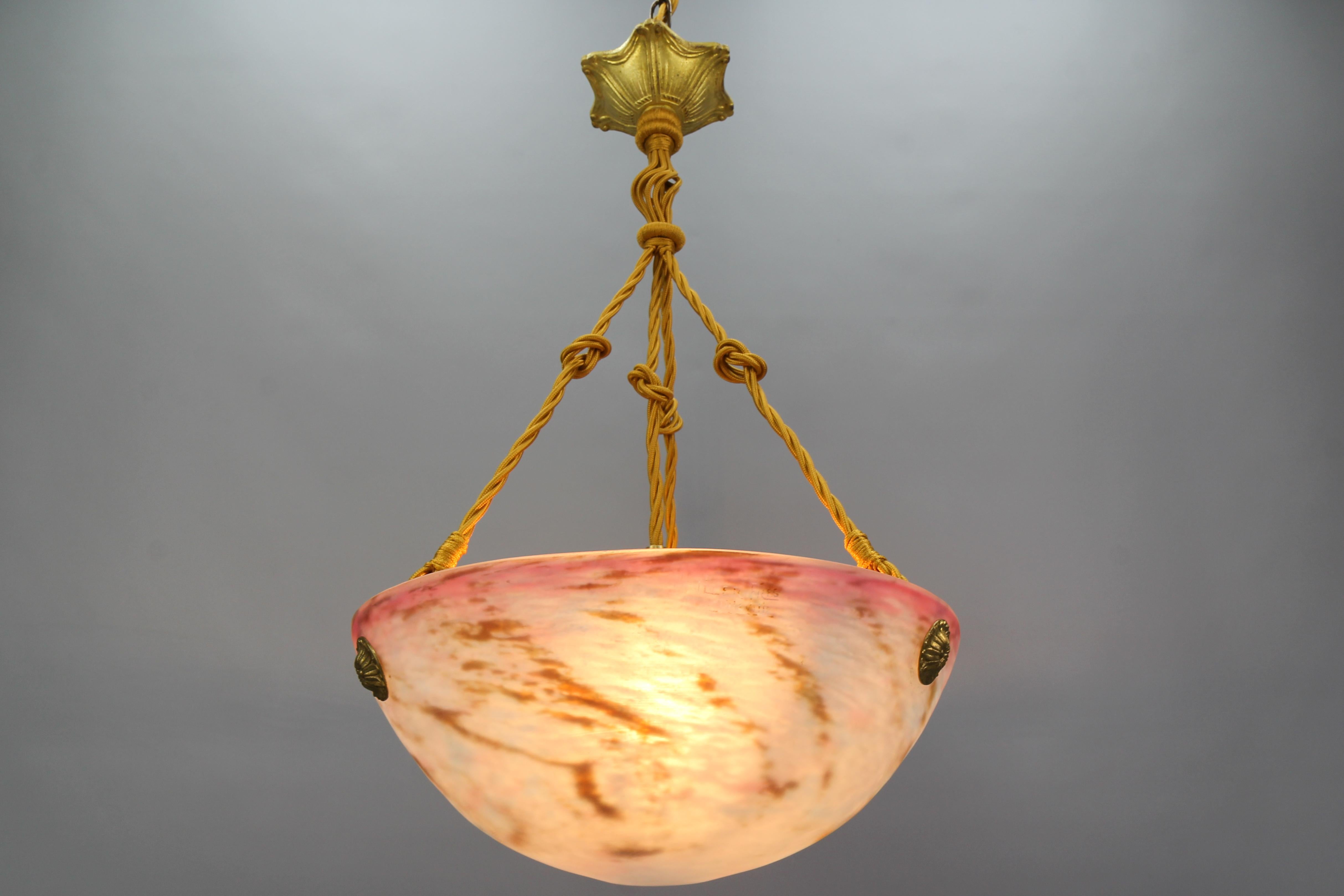 French Art Nouveau bronze and Pâte de Verre glass pendant light fixture by Muller Frères Luneville from circa the 1920s.
This delightful French Art Nouveau period pendant light features a white color 'Pâte de Verre' glass bowl with purple, brown,