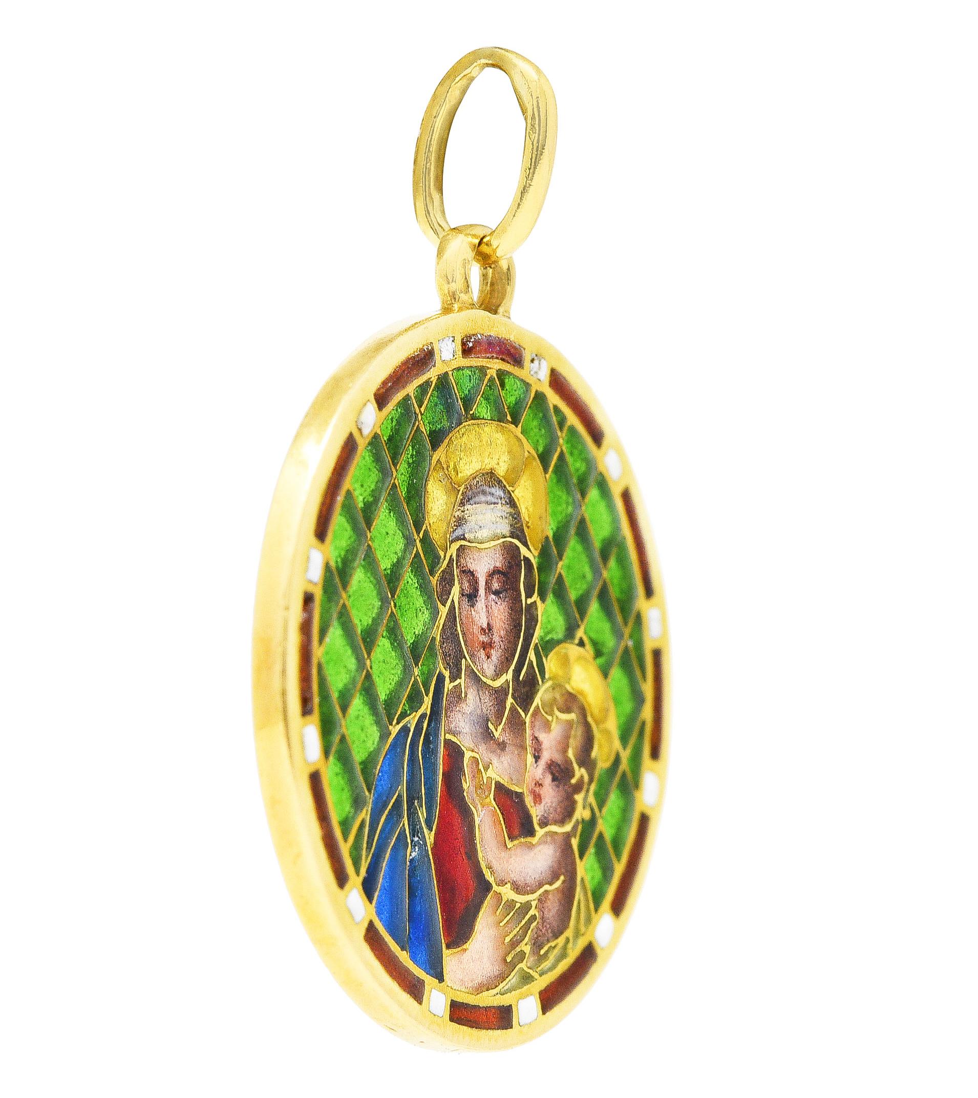 Pendant is designed as a round disk with plique-a-jour enamel depicting the Madonna and Child motif. Figures, bodies and faces are painted with peach, pink, white and brown atop translucent white enamel. With transparent red and blue clothing,