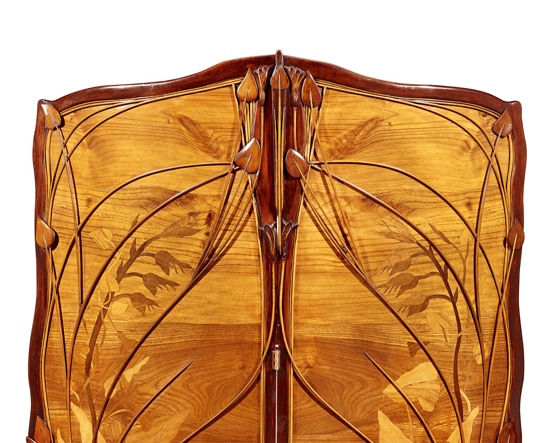 This astounding Art Nouveau room screen is a masterpiece of sinuous aesthetics. Comprising two large panels, the screen is covered in majestic marquetry depicting aquatic flora crafted woods of varying shades framed by applied foliage to tremendous