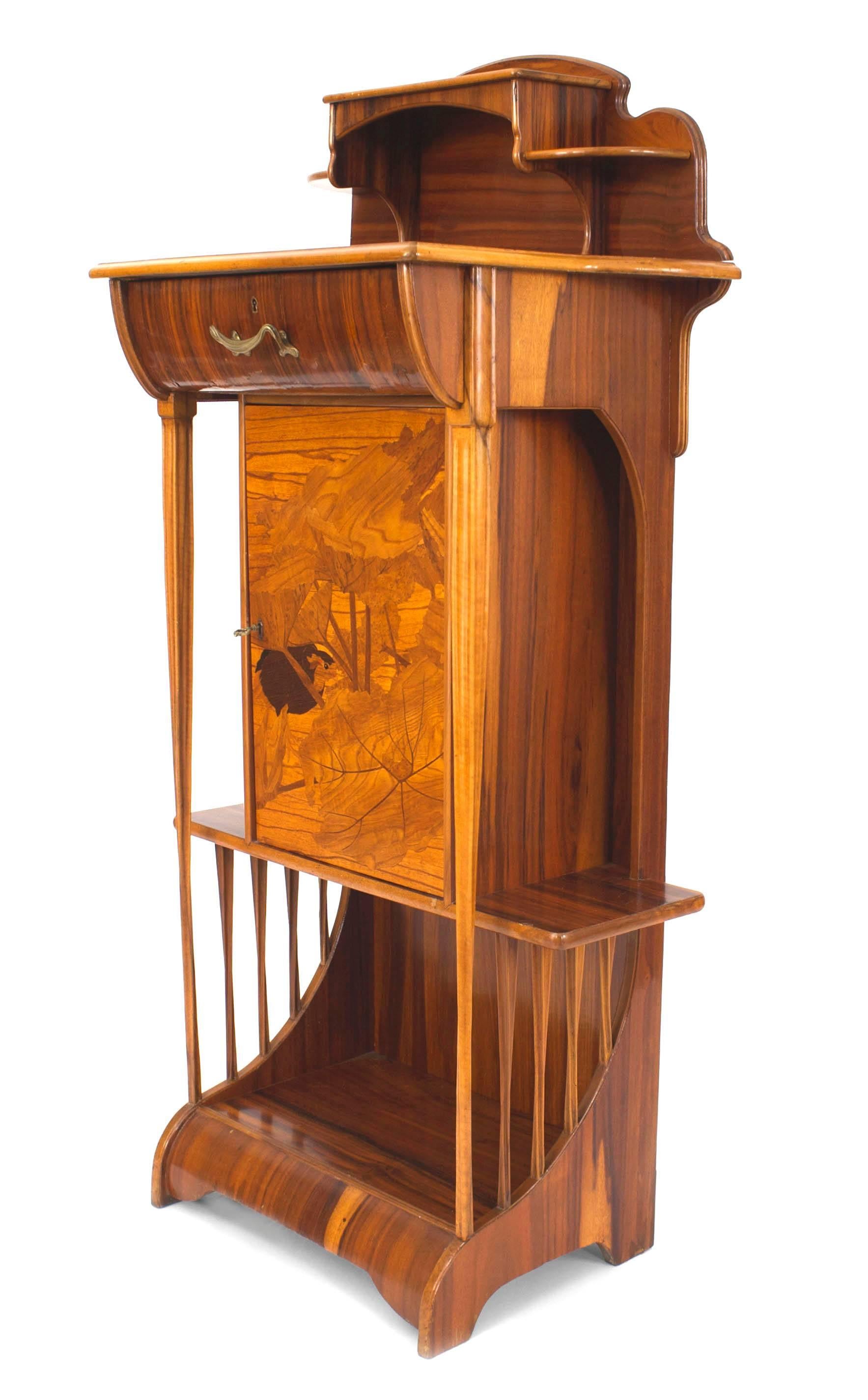 French Art Nouveau rosewood diminutive narrow cabinet with an upper & bottom shelf with side shelves centering a drawer & door having an inlaid bird & forest scene. (MAJORELLE)
