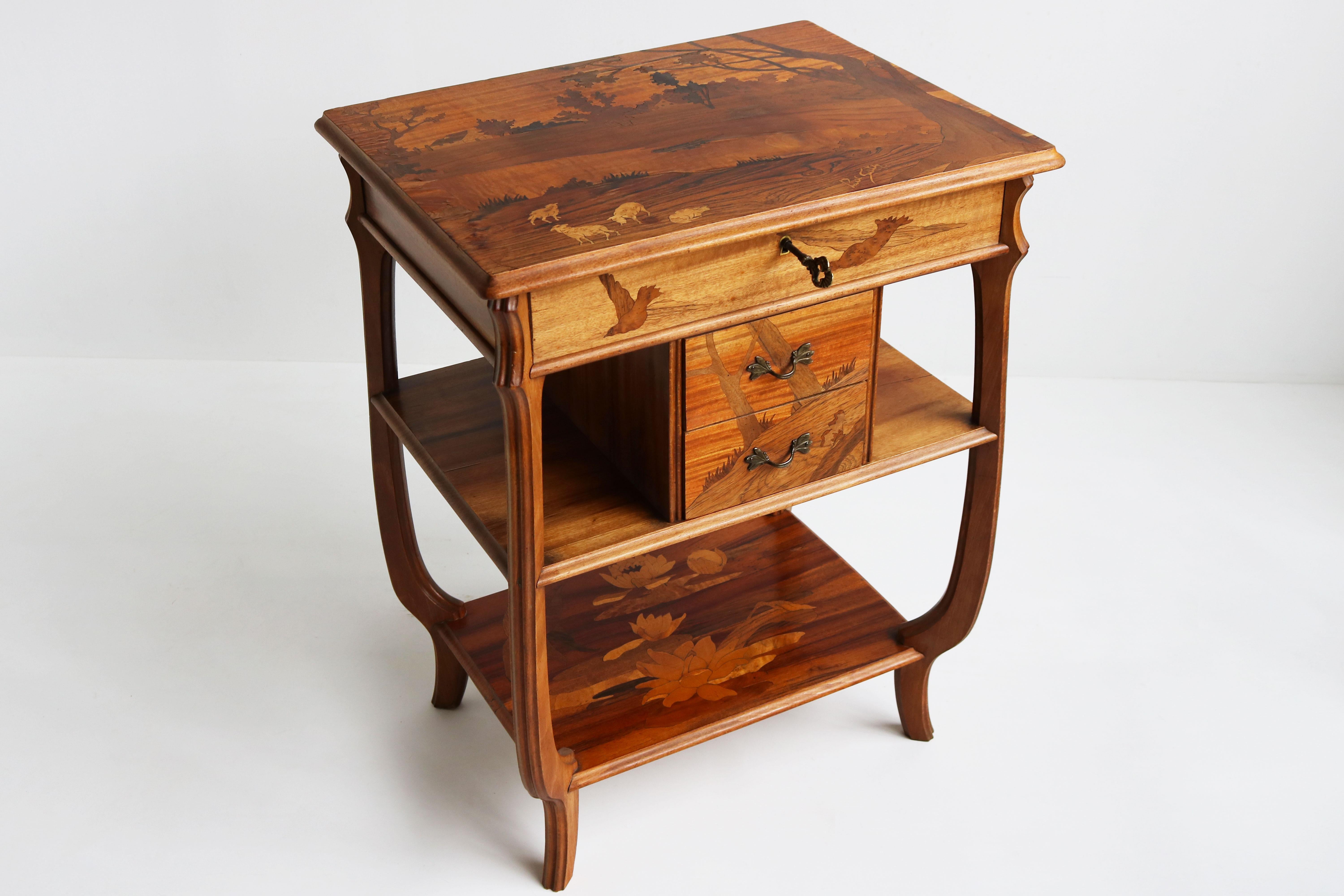 A truly stunning Art Nouveau sewing box / cabinet by Paul Guth 1910. 
The sewing box is decorated with marvelous inlays: On top a typical French scenery with farms , goats , trees & a river. 
On the front 2 birds , on the drawers a mountain with