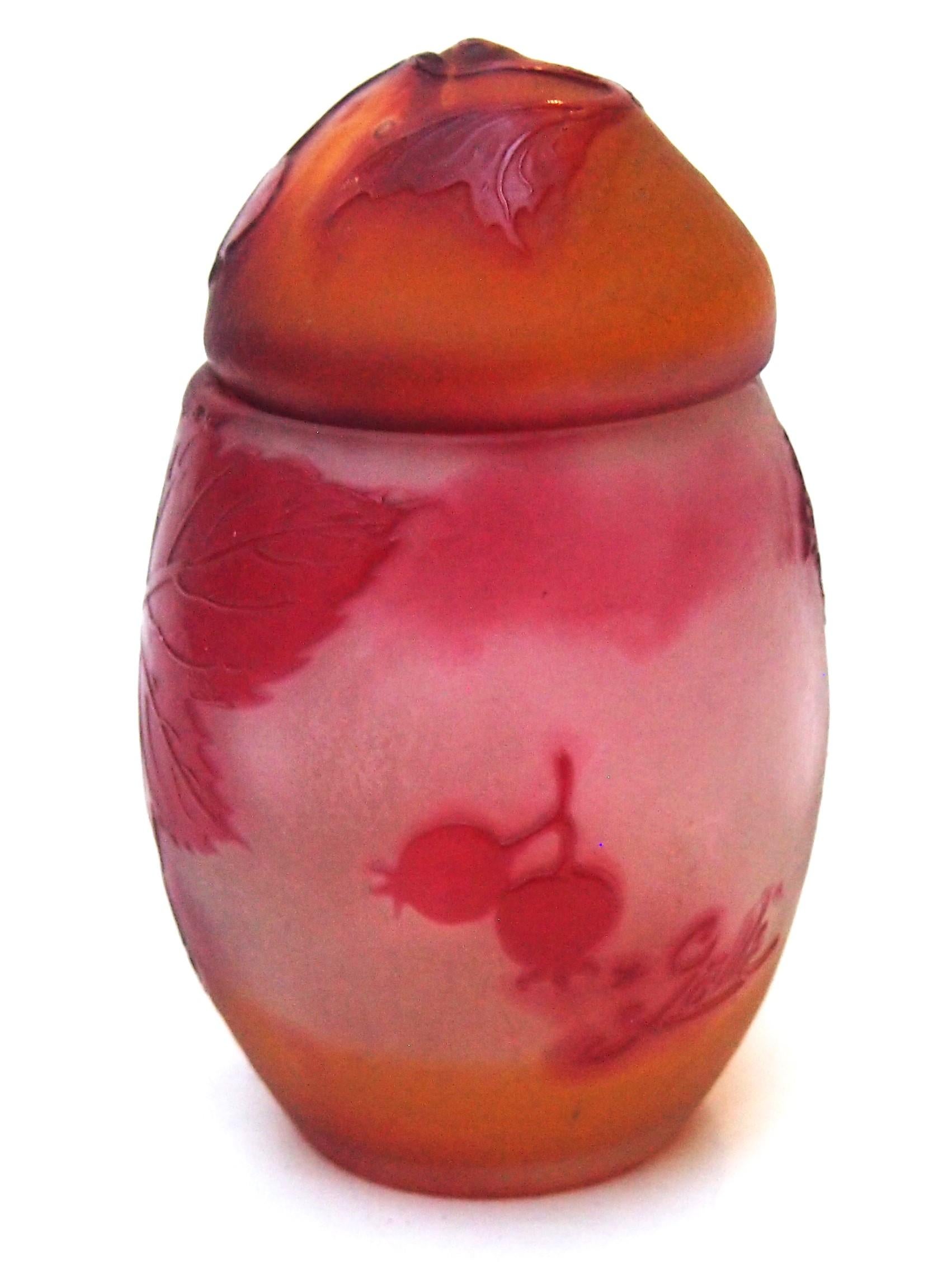 Una rareza  Caja y tapa de huevos de Pascua firmados por Emile Galle en rojo y naranja sobre transparente. La pieza representa finas hojas y bayas, uno de los motivos primitivos más clásicos. Tiene la rara forma de una caja de huevos de Pascua con
