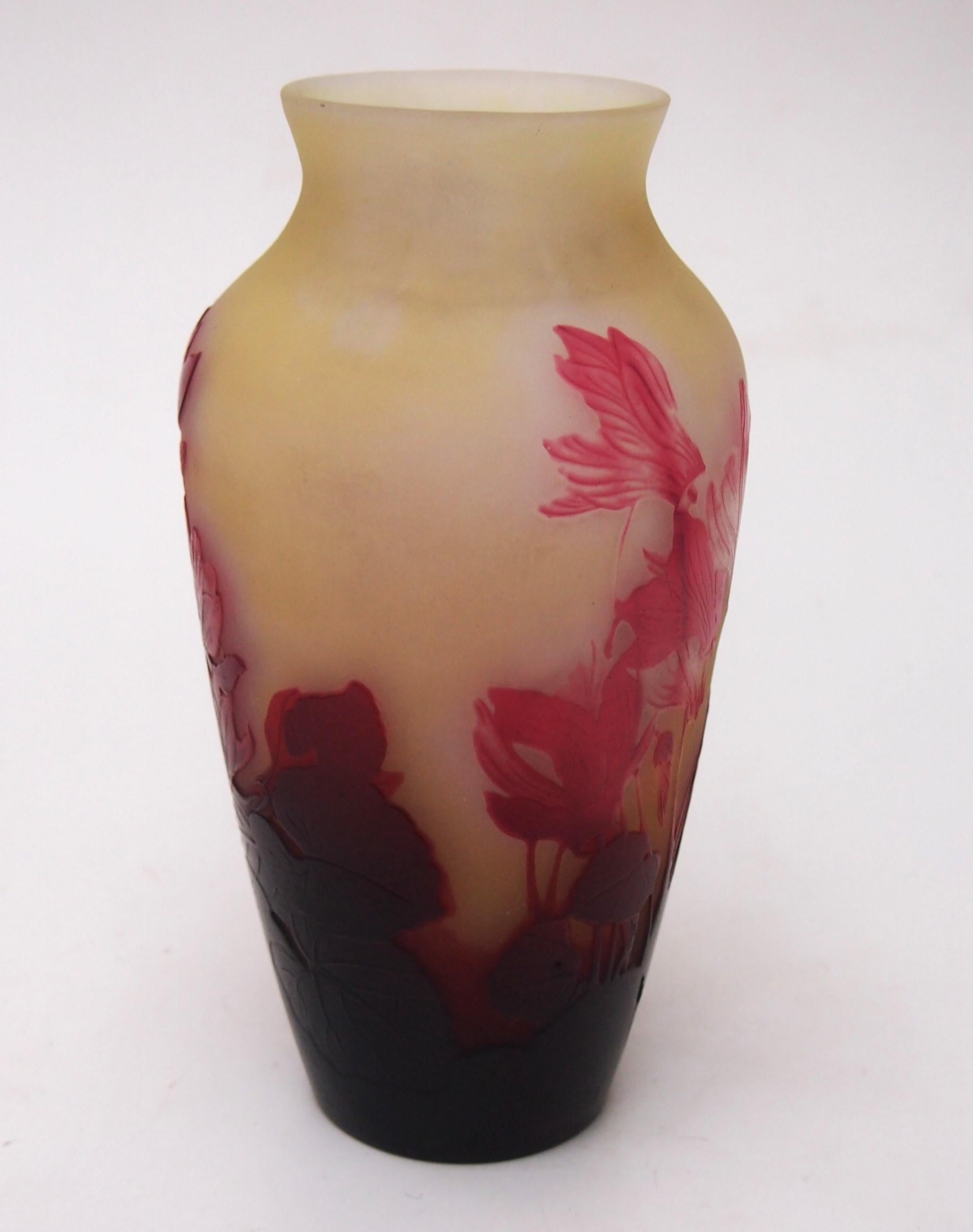 Un espectacular jarrón camafeo francés Art Nouveau Emile Gallé que representa múltiples ciclámenes en flor en rojos sobre amarillo anaranjado, con un fino pulido interno para resaltar el rojo de las flores -las flores están barridas por el viento,