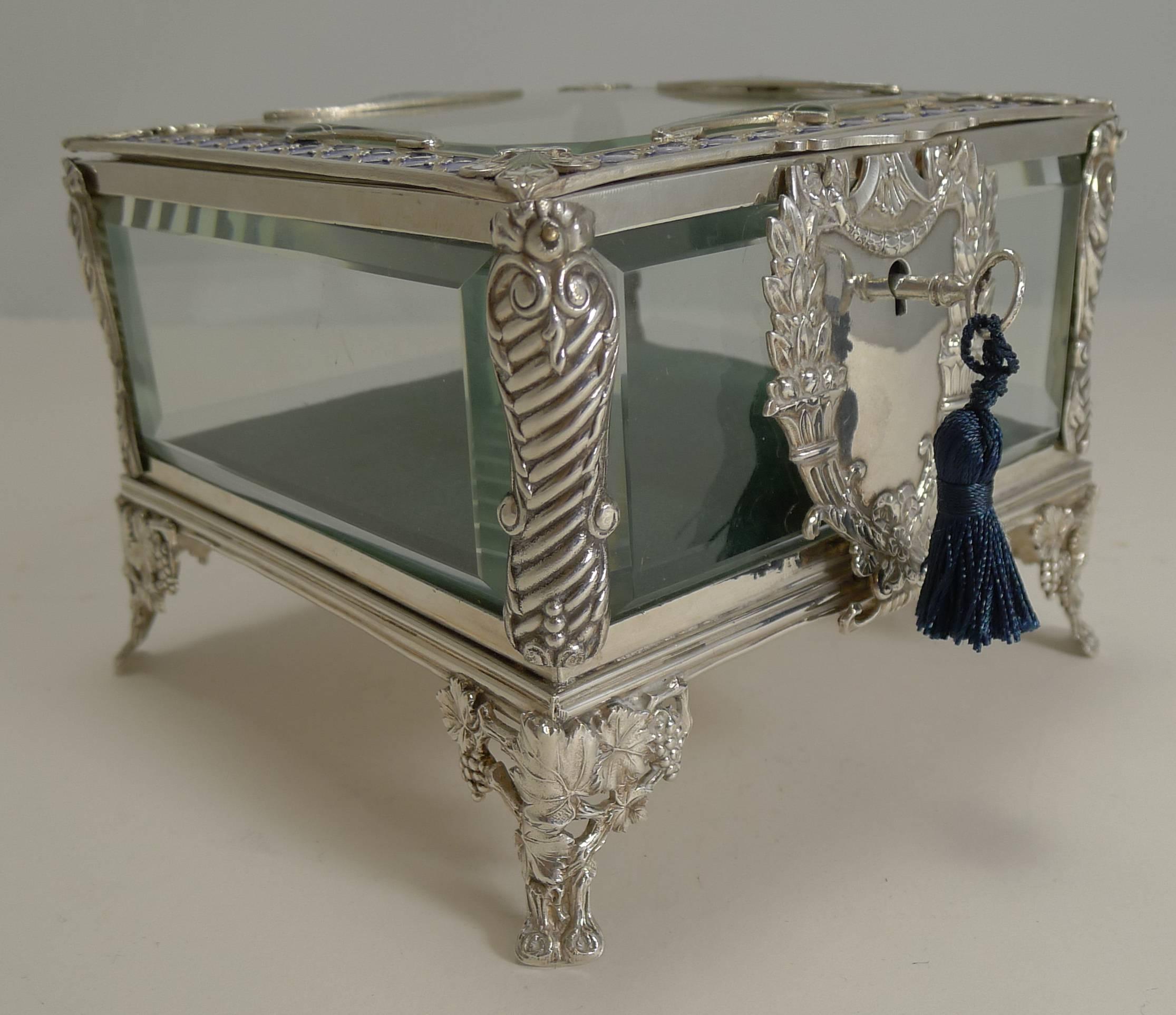 An absolutely splendid French jewellery casket made from silver plate, retaining the original panels of cut-glass.

The box stands on four highly decorative feet with a grapevine decoration and the front having the most grand escutcheon housing