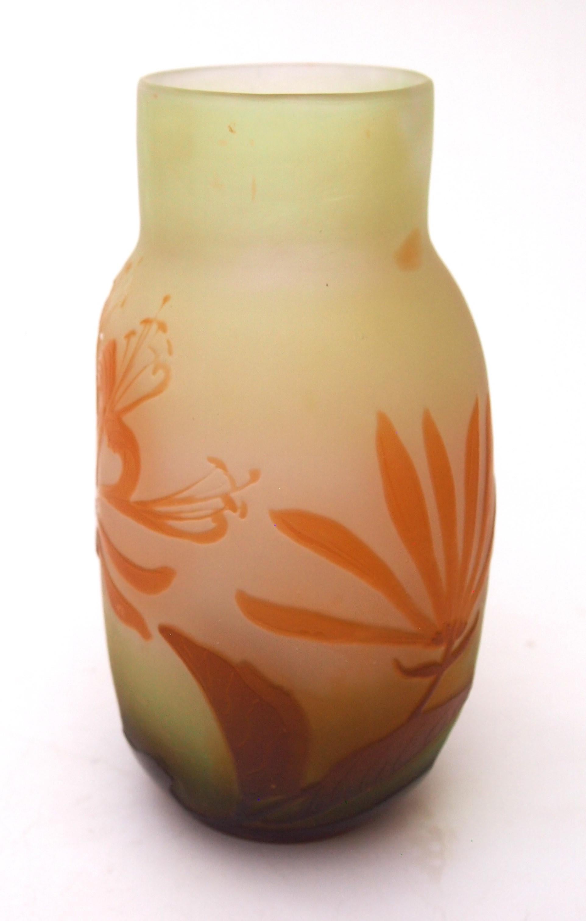 Cute and early Emile Galle cameo vase in vibrant orange and dark brown over pale green -a oval shaped vase depicting dramatically flowering large honeysuckle blooms. It is signed in raised cameo -and has an early signature one only used within his