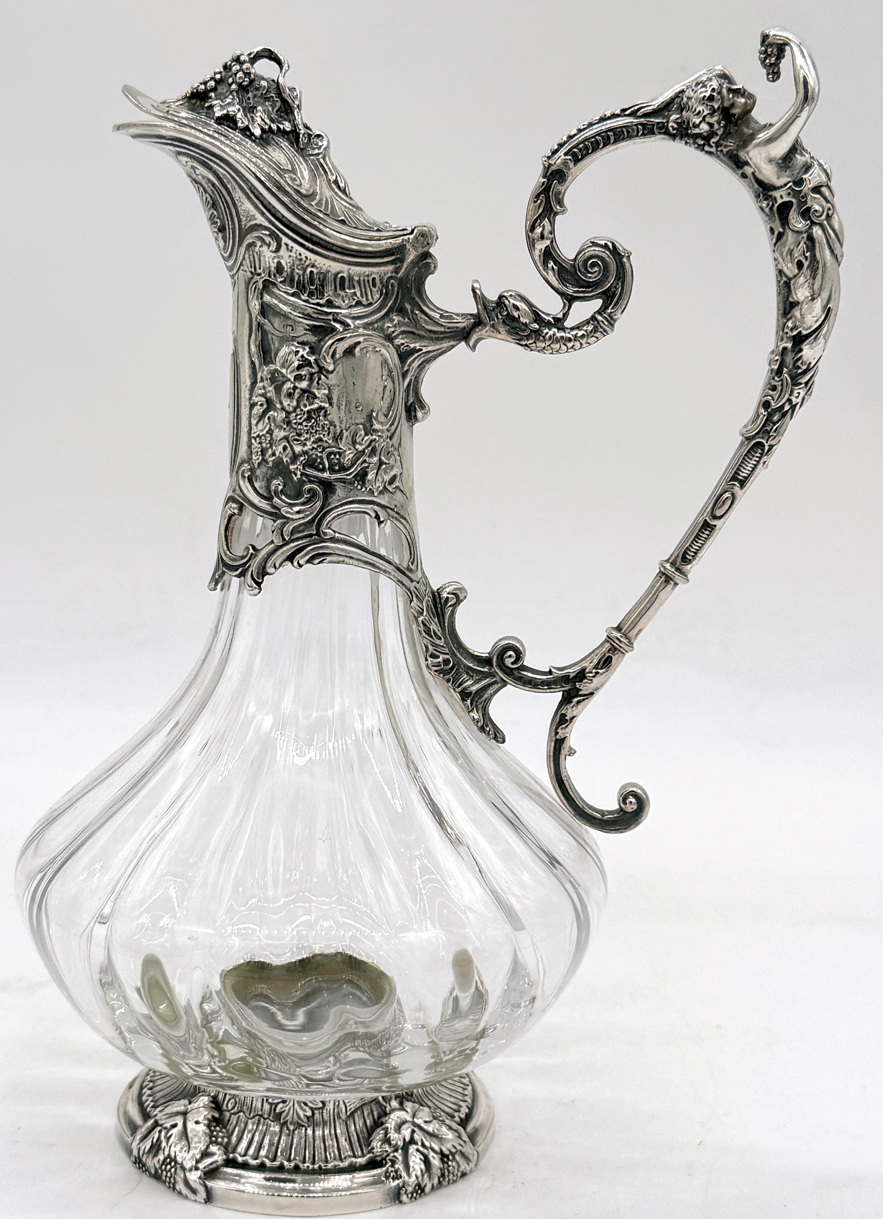 Jarra de clarete francesa de plata y cristalería Lorraine de estilo Art Nouveau 

Esta exquisita jarra de clarete figurada de estilo Art Nouveau francés mide 15 cm de alto, 7,5 cm de ancho y 5,5 cm de fondo. La jarra tiene un asa de odalisca